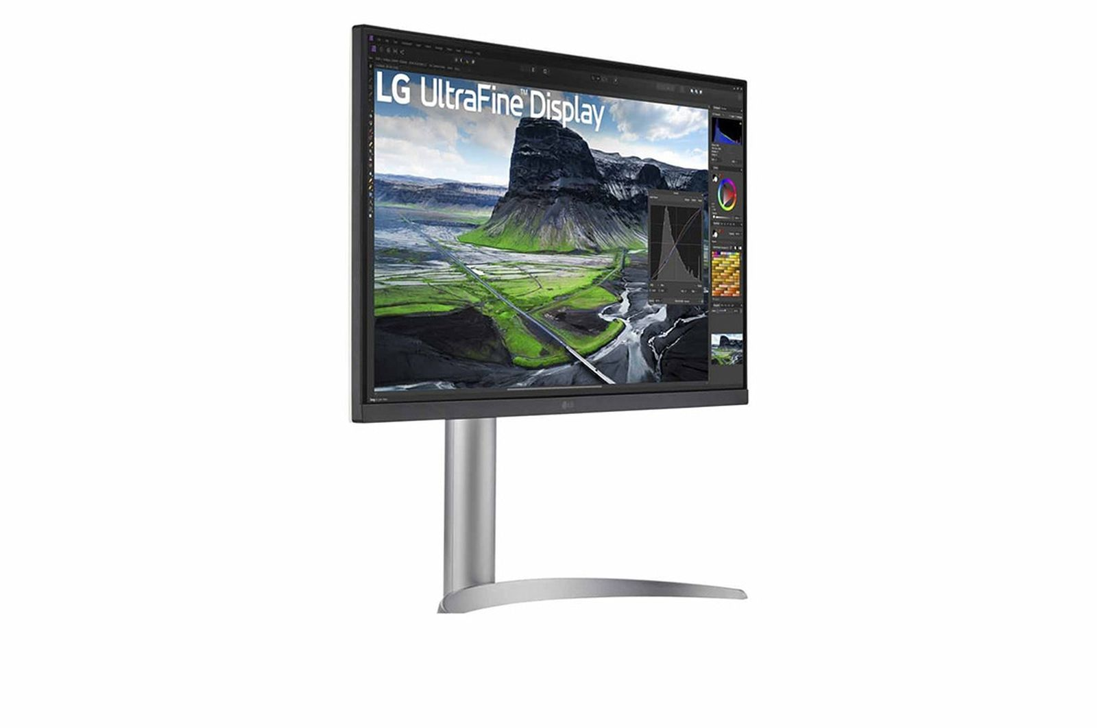 Monitor LG UltraFine Display. Wyświetla krajobraz z górami i zielonymi polami. Ma srebrną podstawę i czarną ramkę.
