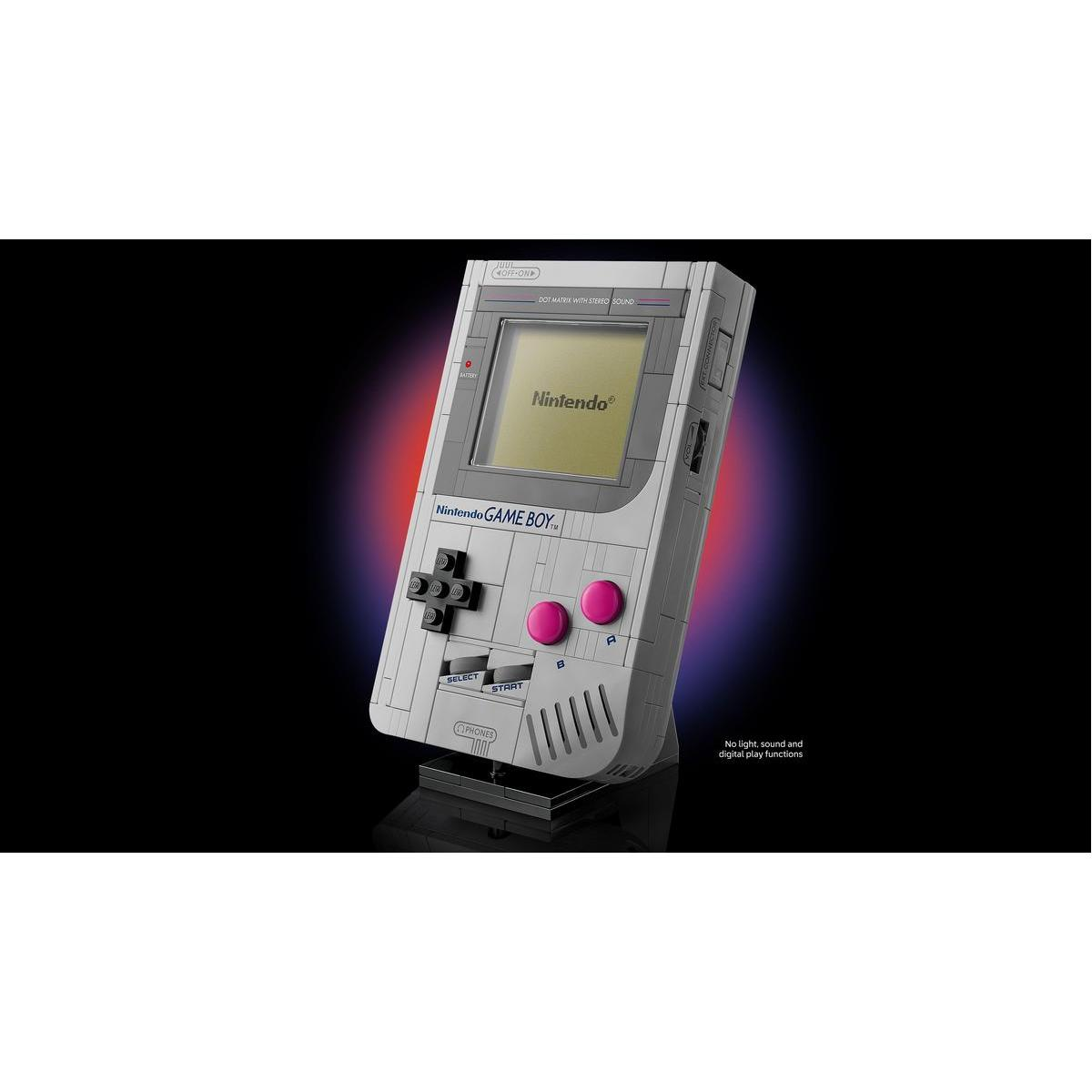 Ein grauer Nintendo Game Boy steht auf einem schwarzen Sockel. Er hat Knöpfe, einen Bildschirm mit dem Nintendo-Logo und einen rot-violetten Hintergrund.