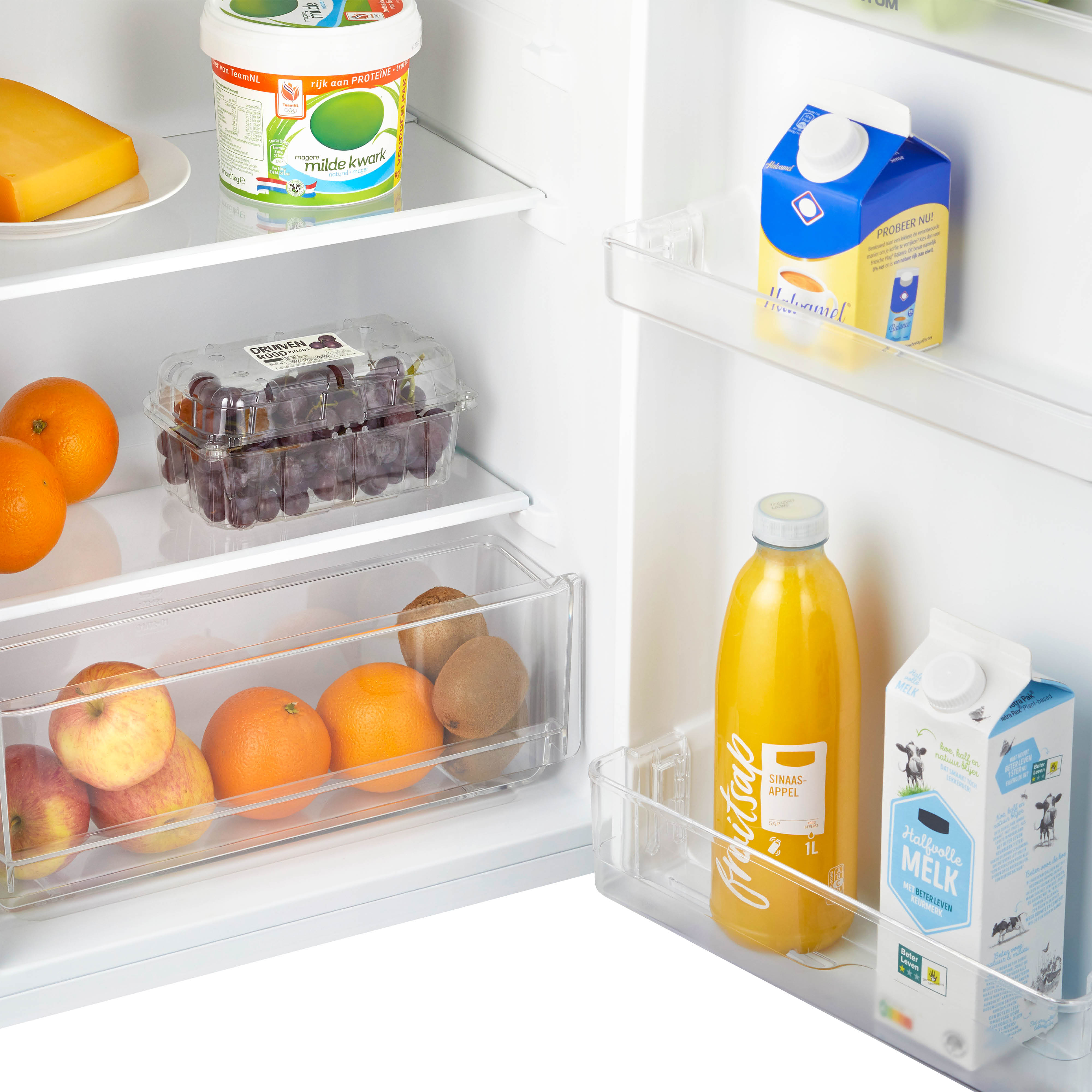 Refrigerator interior with cheese, grapes, oranges, juice, milk, and yogurt.