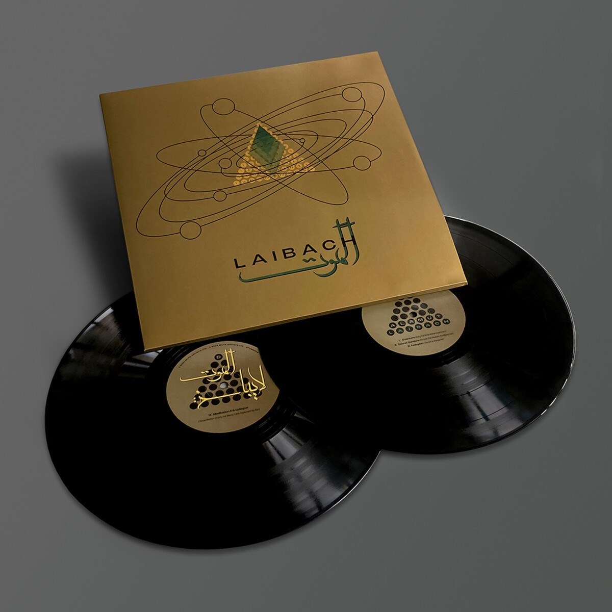 Due dischi in vinile neri con una copertina dorata. La copertina presenta la parola LAIBACH e un design grafico. I dischi sono su sfondo grigio.