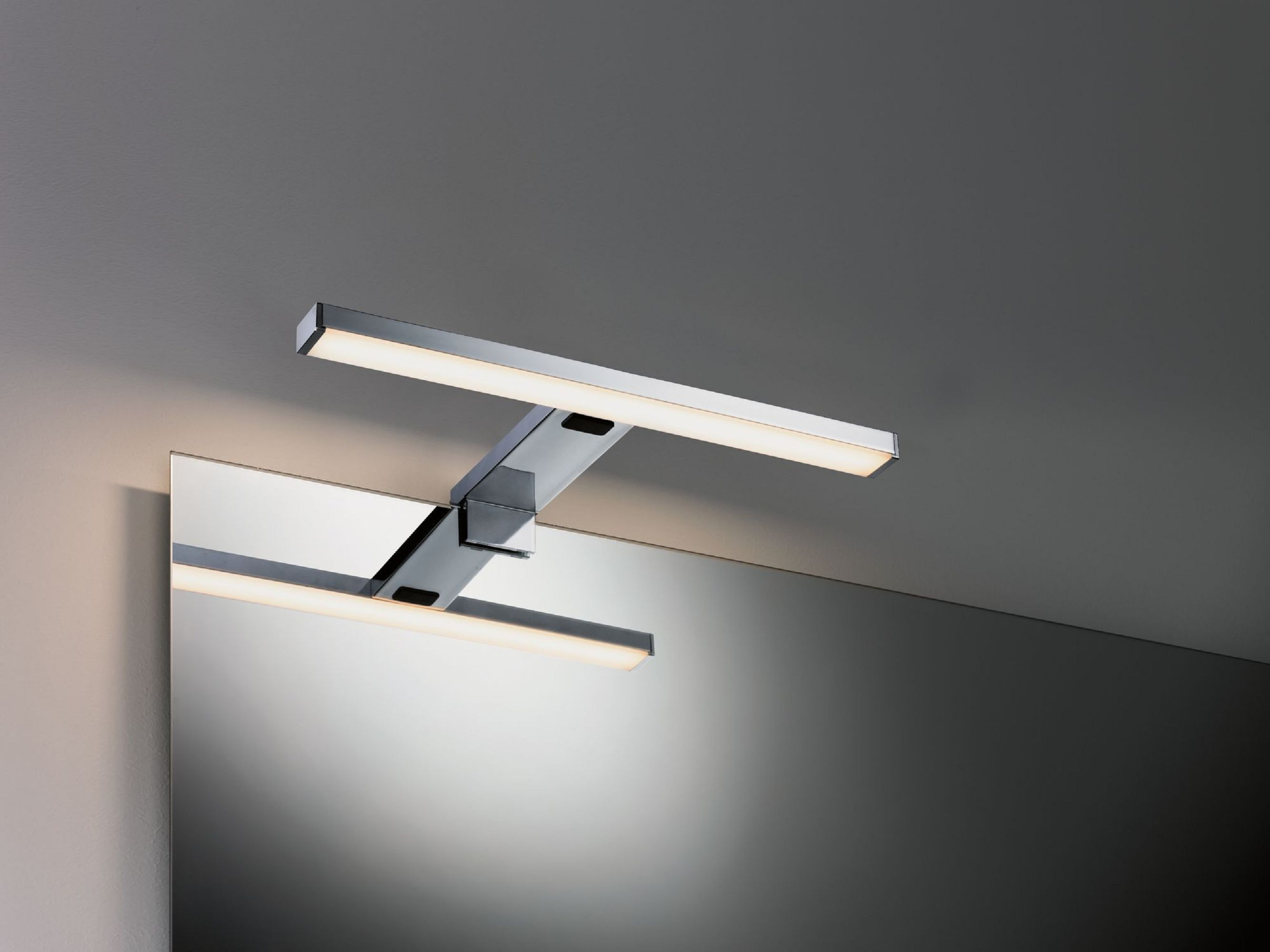 Un moderno apparecchio di illuminazione per il bagno. È metallico e contiene due barre luminose orizzontali sopra uno specchio.