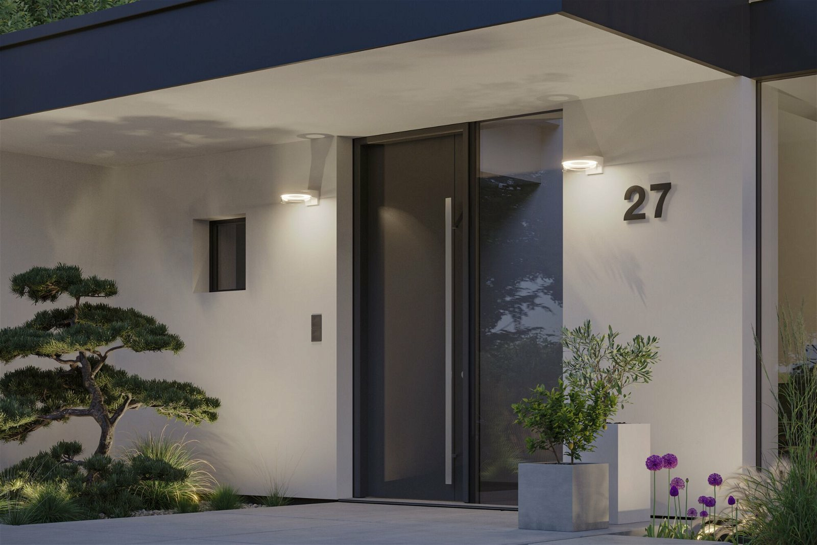 Nowoczesne wejście do domu z drzwiami, światłami i roślinami. Numer 27 na ścianie. Zielone rośliny na pierwszym planie i w tle.