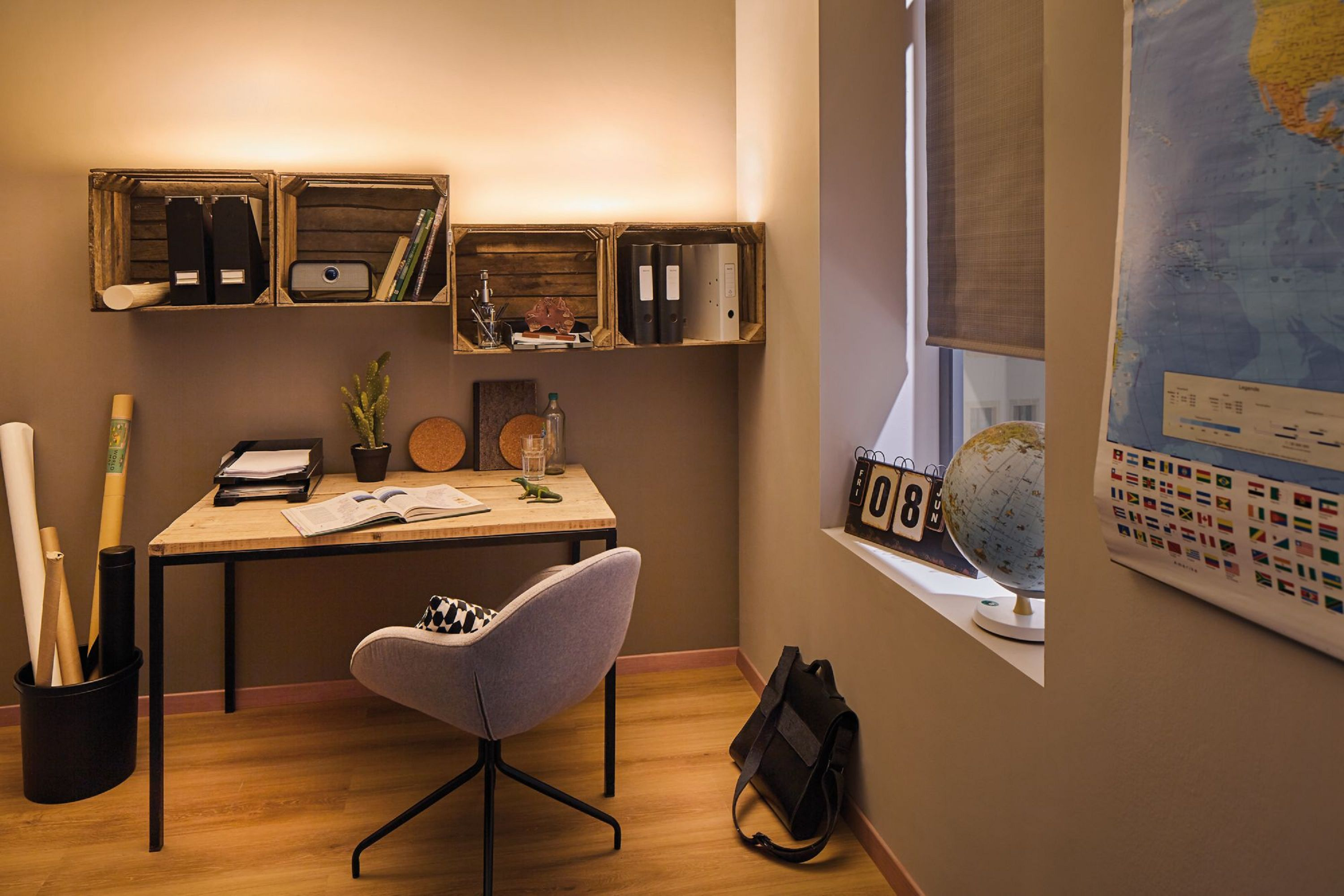 Ein Heimbüro mit Schreibtisch, Stuhl, Regalen und Fenster. Ein Globus, eine Karte und eine Tasche sind ebenfalls vorhanden.