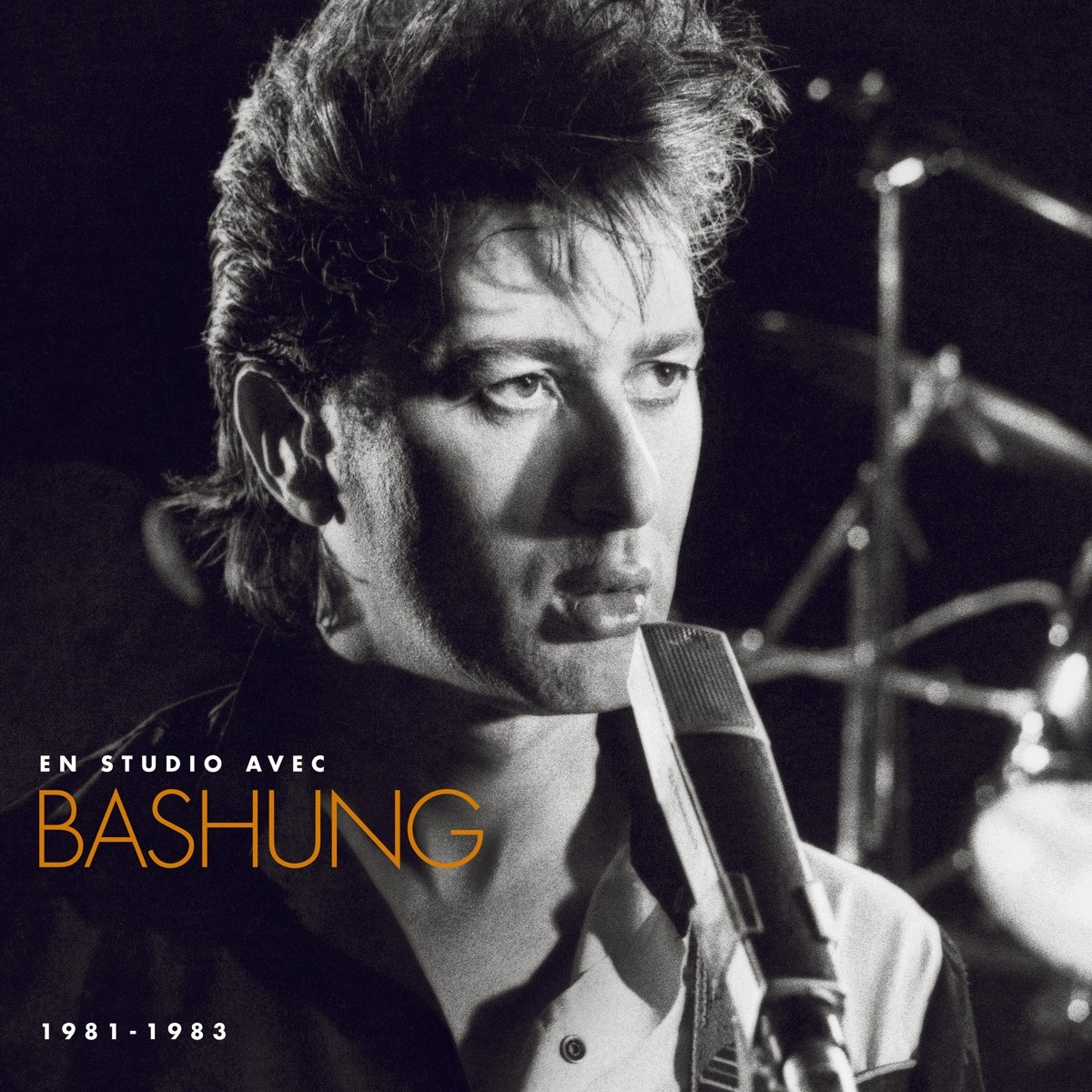 Copertina dell'album in bianco e nero. Uomo con microfono, testo Bashung, 1981-1983. Luci di scena sullo sfondo.