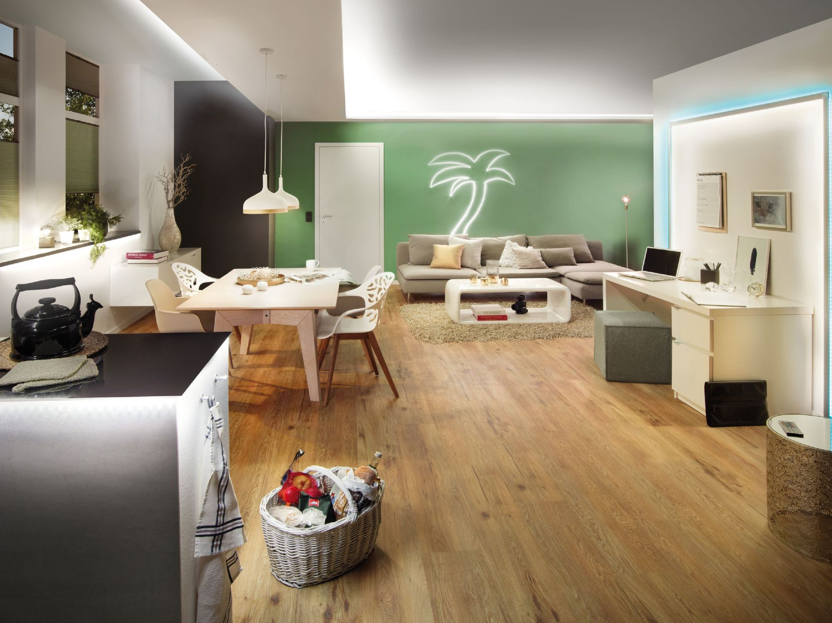 Nowoczesny salon. Posiada stół jadalny, sofę, kuchnię i biurko. Neonowy znak z palmą na ścianie.