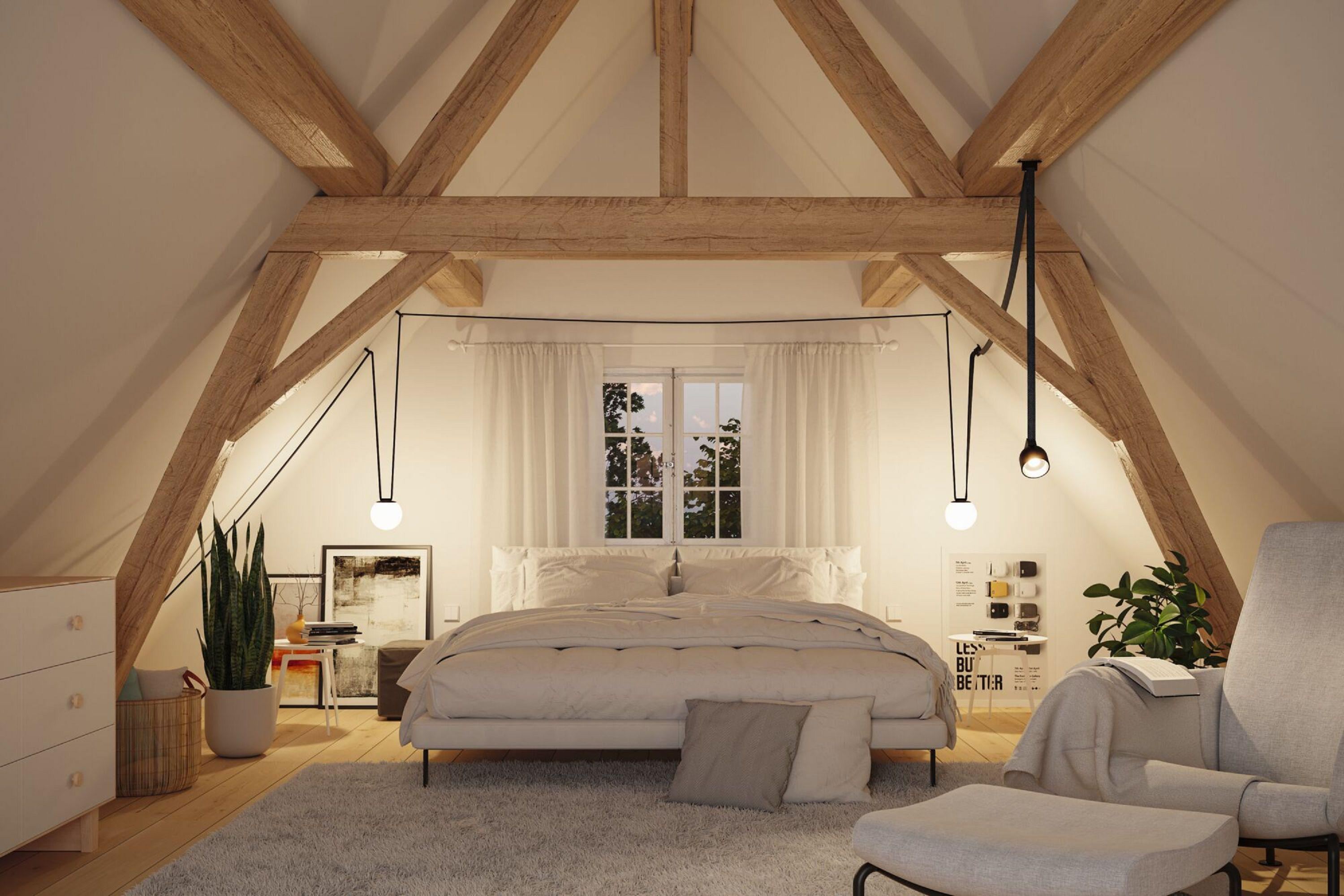 Intérieur de chambre avec poutres en bois, lit, fenêtre et lampes. Des plantes et une chaise sont également visibles. L'éclairage est doux.