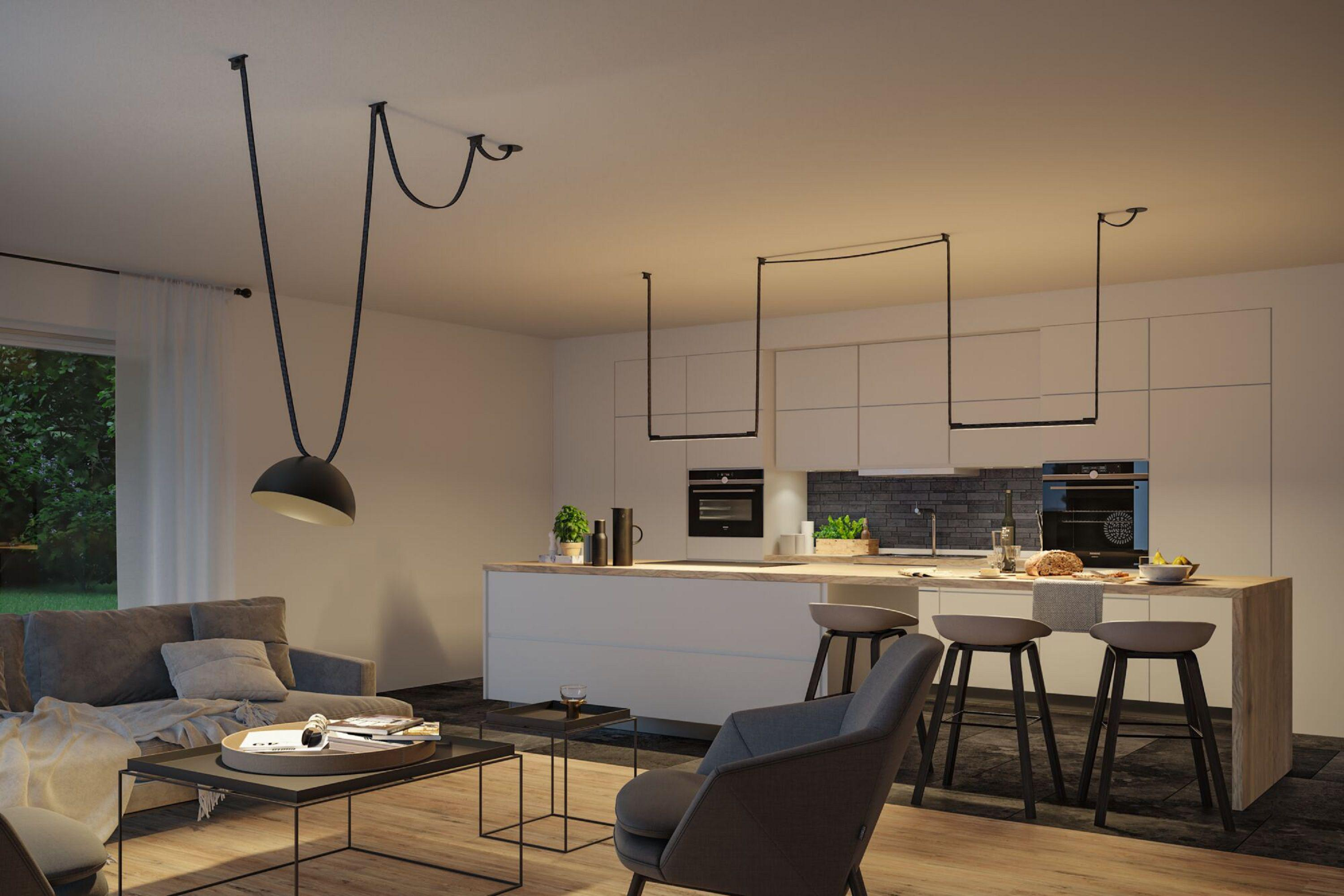 Une cuisine et un salon modernes avec des lampes suspendues, un canapé et un îlot de cuisine avec des tabourets. La scène est bien éclairée.