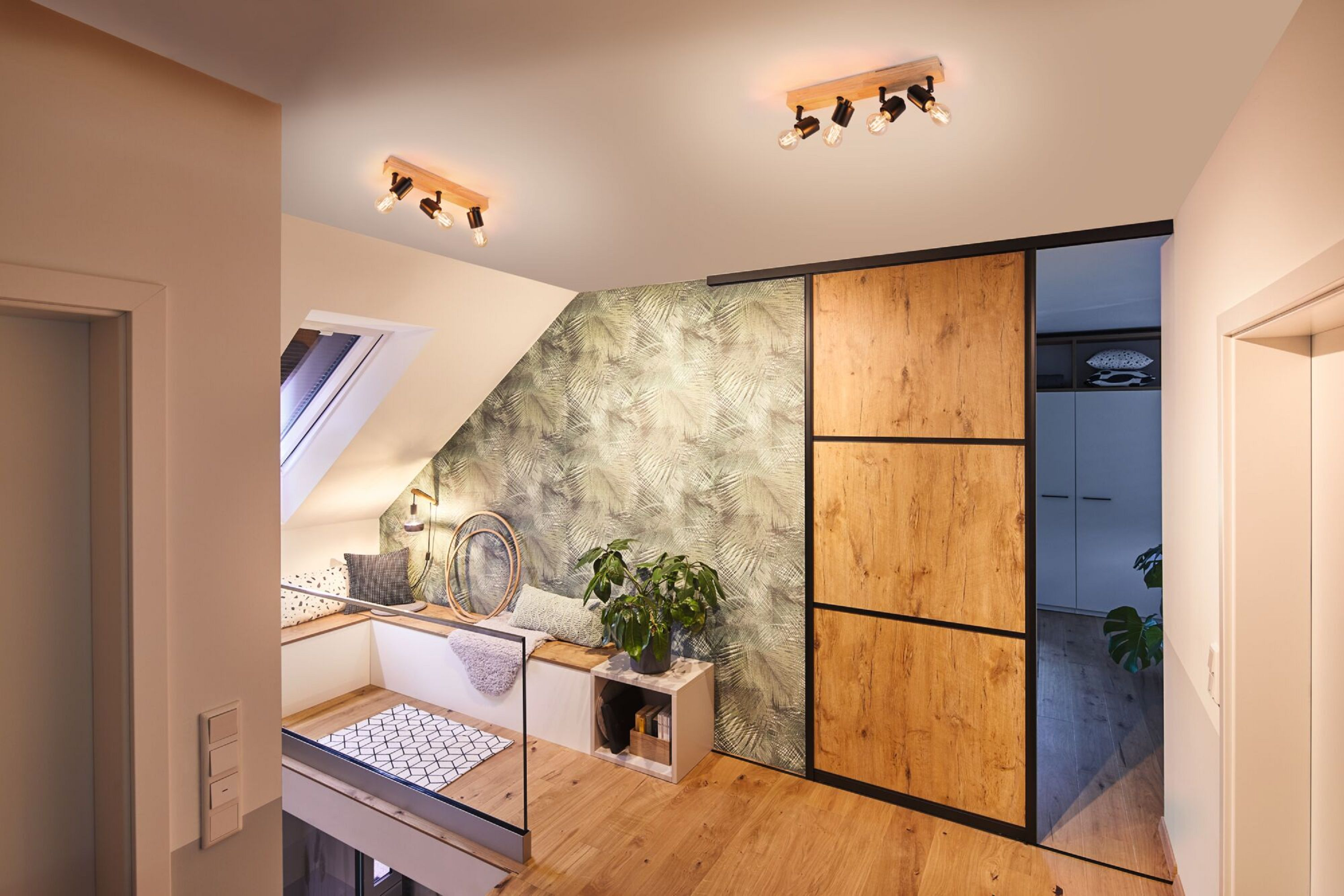 Wnętrze nowoczesnego apartamentu. Drewniane podłogi i drzwi, wzorzysta ściana, wbudowane siedzenia i reflektory.