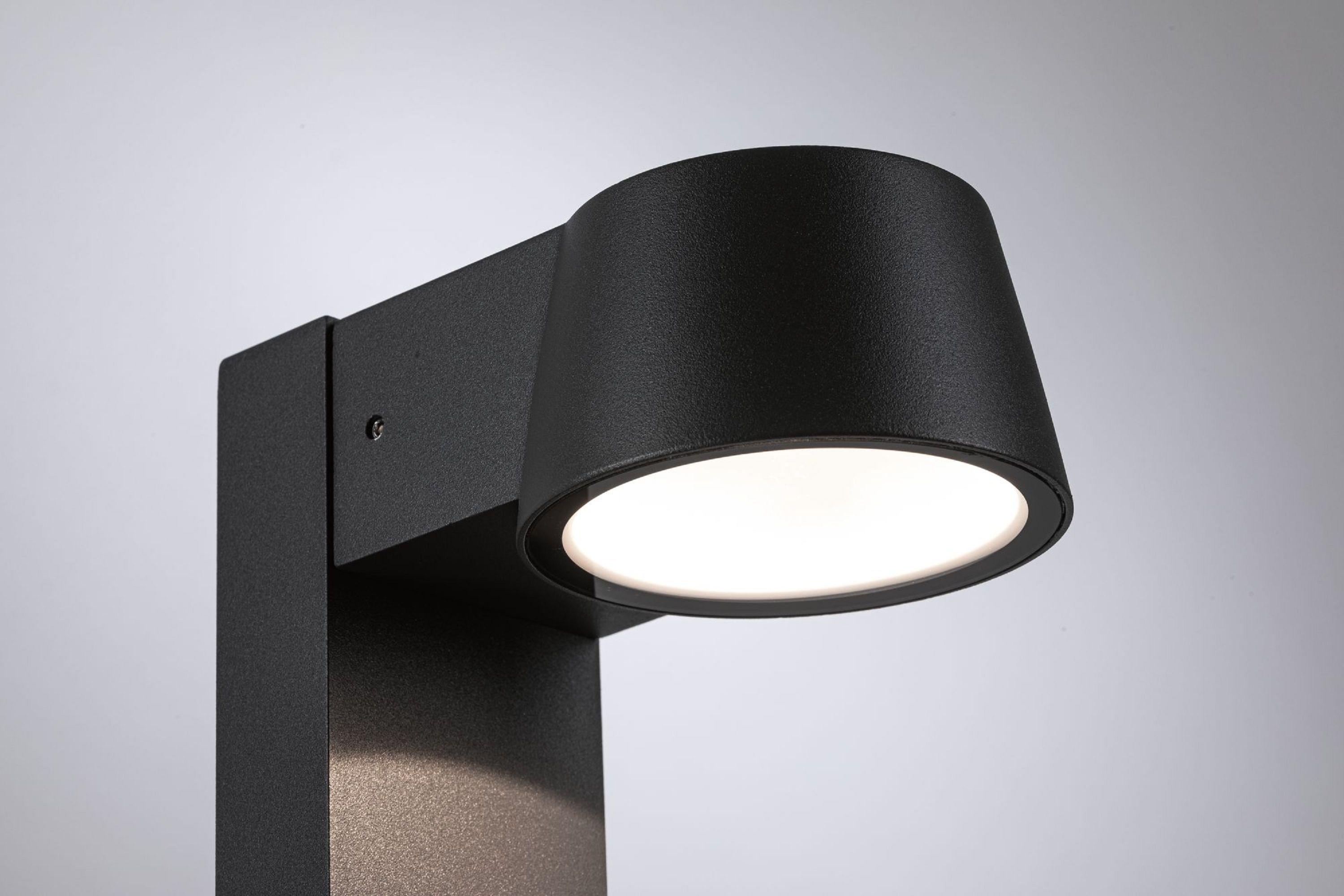 Czarna, nowoczesna lampa zewnętrzna z jasnym światłem na białym tle gradientowym.