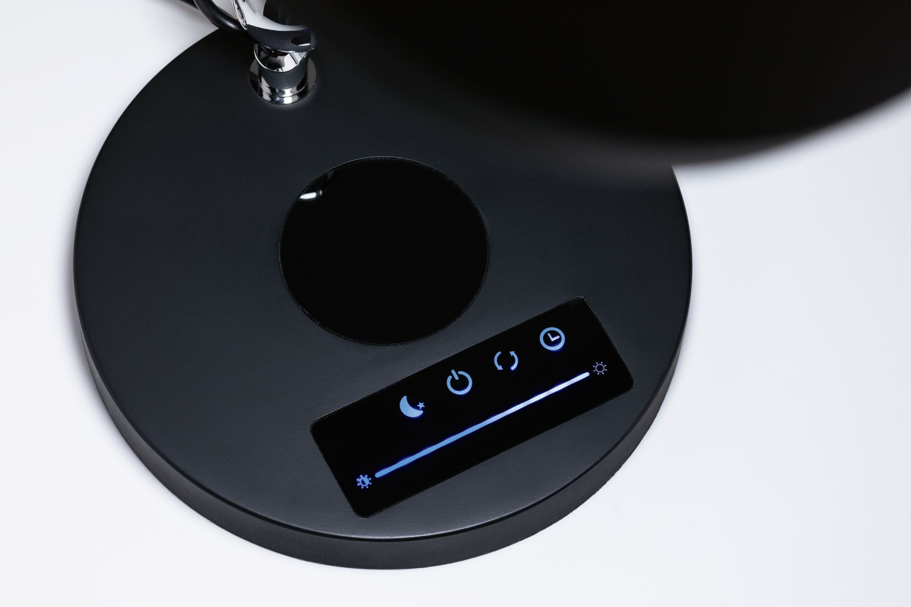 Ein schwarzer Lampensockel mit Touch-Bedienelementen. Knöpfe zeigen Strom, Einstellungen und Helligkeit. Ein Chromarm ist befestigt.