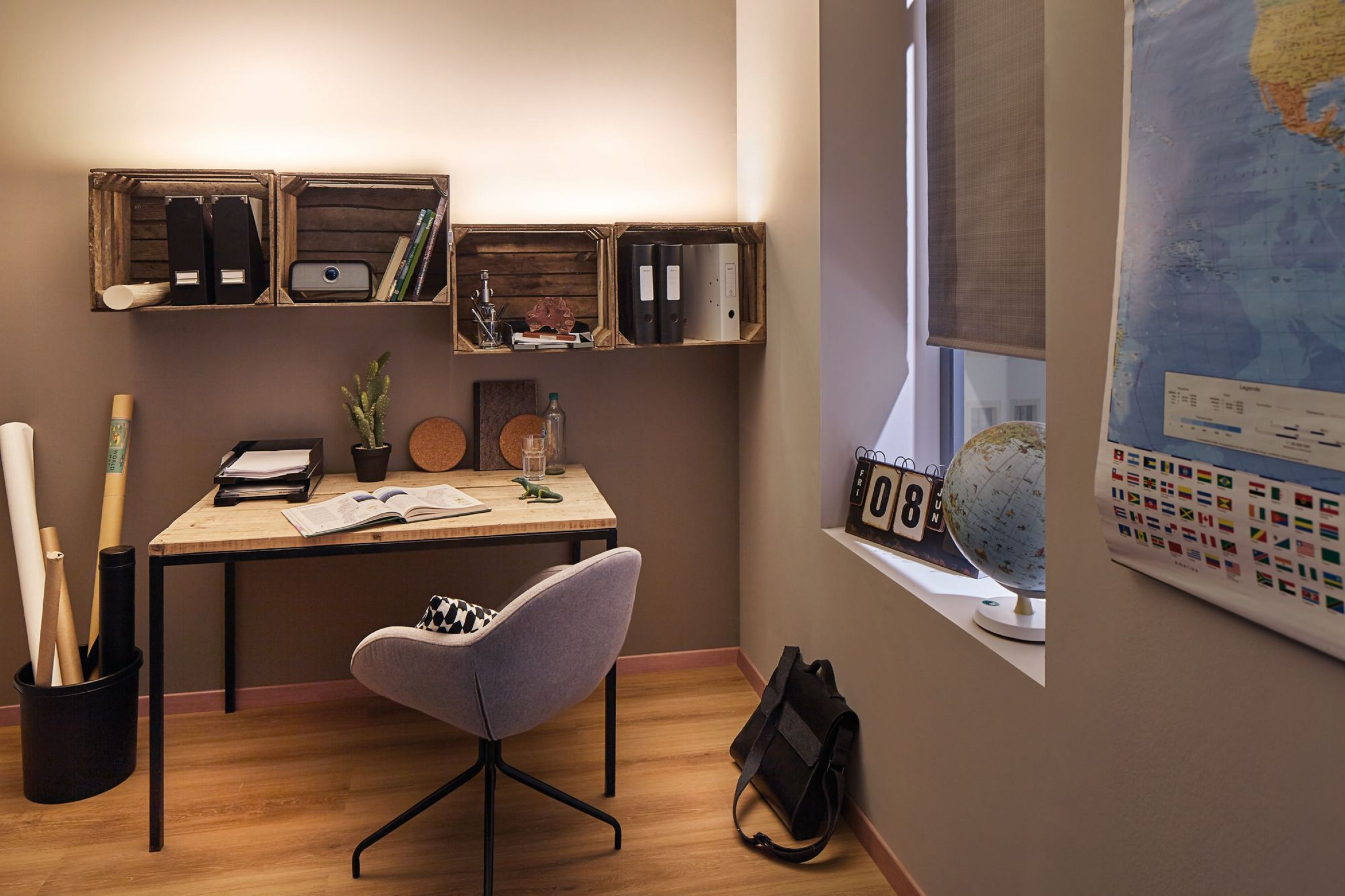 Domowe biuro z biurkiem, krzesłem i półkami. Okno z globusem i kalendarzem po prawej.