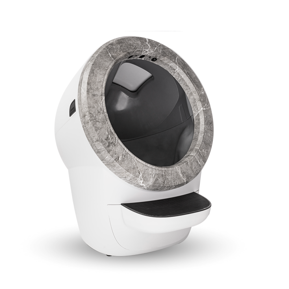 Arenero automático para gatos blanco y gris. Tiene un borde similar al mármol y un escalón negro en la base.