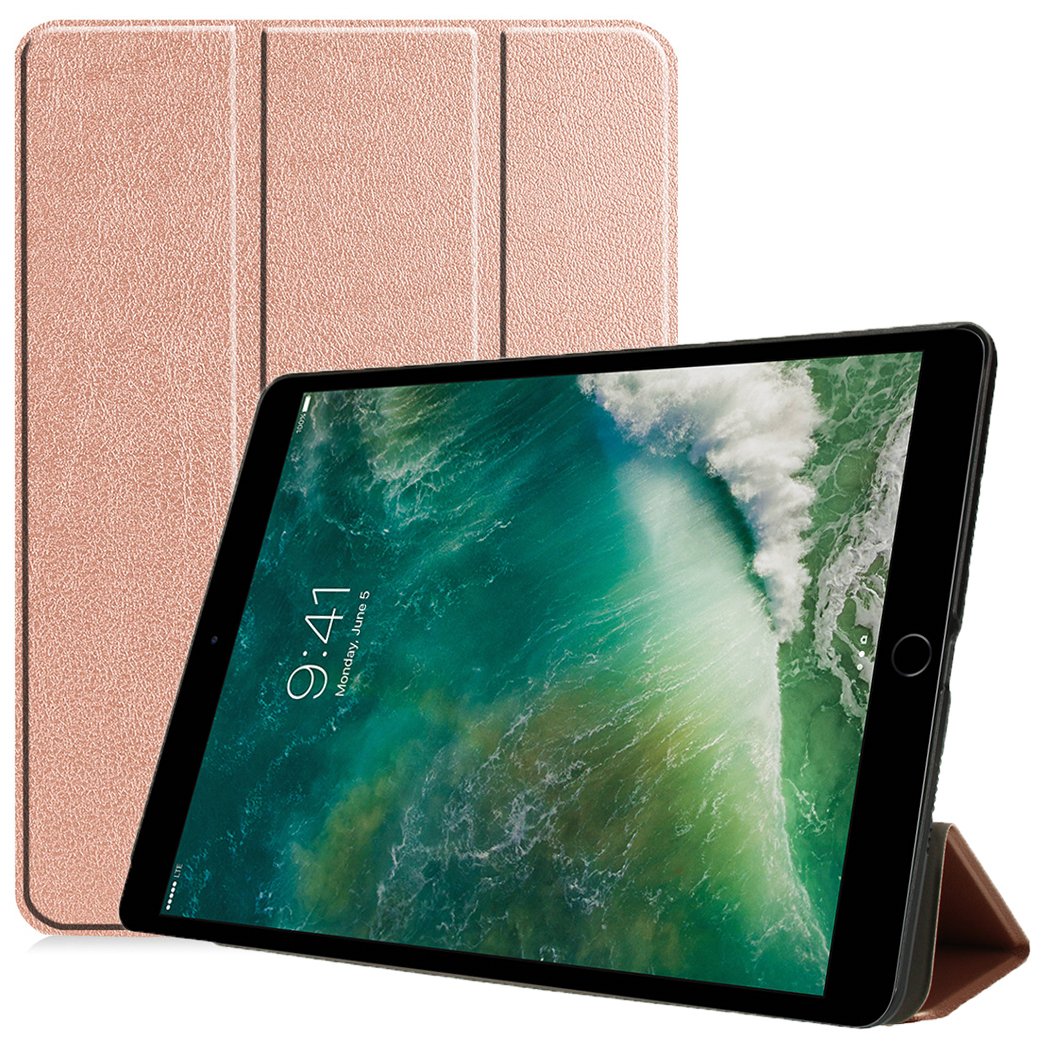A tablet with a screen showing a landscape image is propped up. A pink case stands behind it.