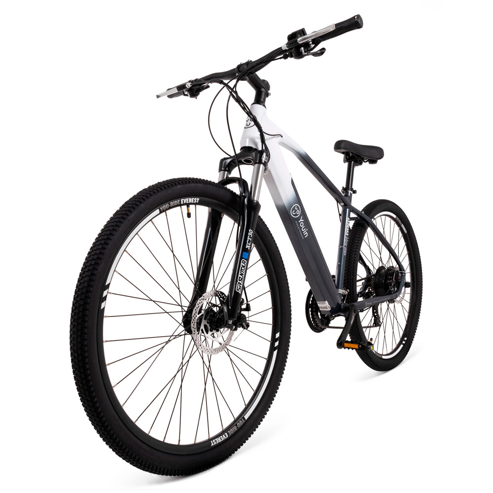 Ein Elektrofahrrad steht vor weißem Hintergrund. Das Fahrrad ist schwarz und weiß mit großen Reifen und einem Akku.