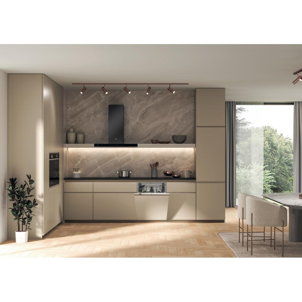 Nowoczesna kuchnia z beżowymi szafkami, czarnymi urządzeniami i drewnianą podłogą. Zmywarka jest otwarta. Duże okno pokazuje drzewa.