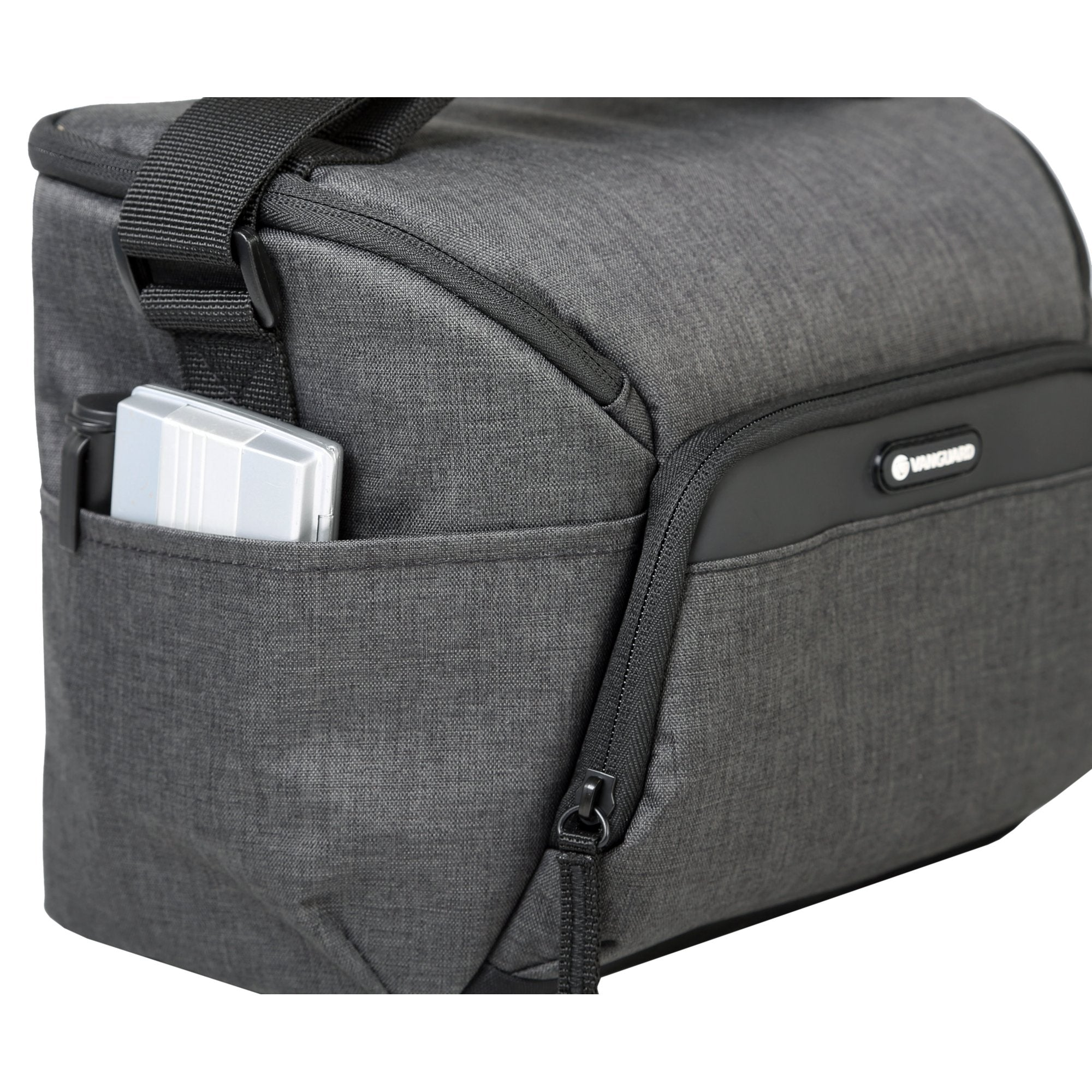 Una bolsa de cámara gris con un bolsillo que contiene una funda plateada. La bolsa tiene cremallera y correa negras. Logotipo de Vanguard visible.