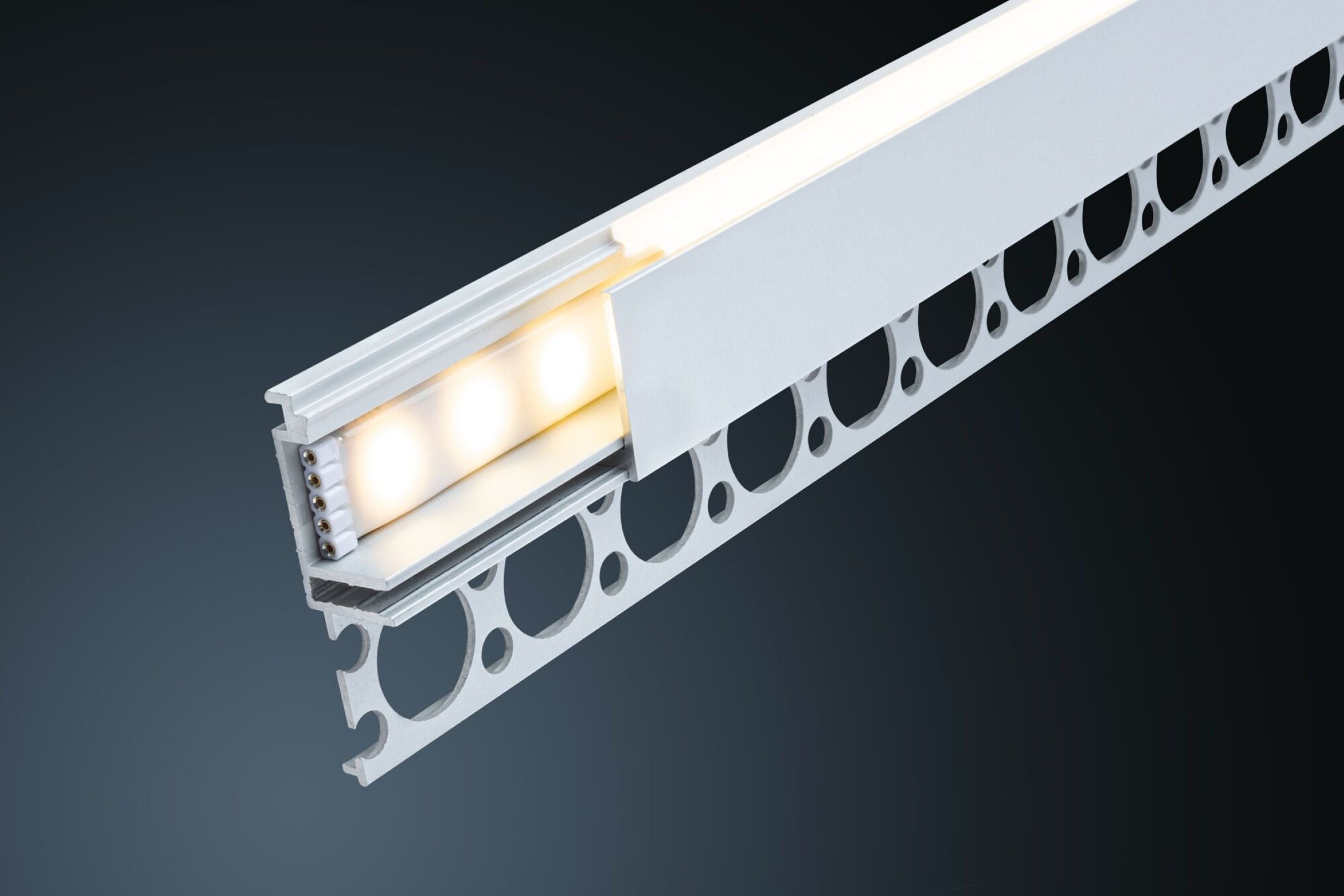 Querschnitt einer weißen LED-Leuchte. Sie hat eine perforierte Seite und beleuchtete LEDs im Inneren, vor dunklem Hintergrund.