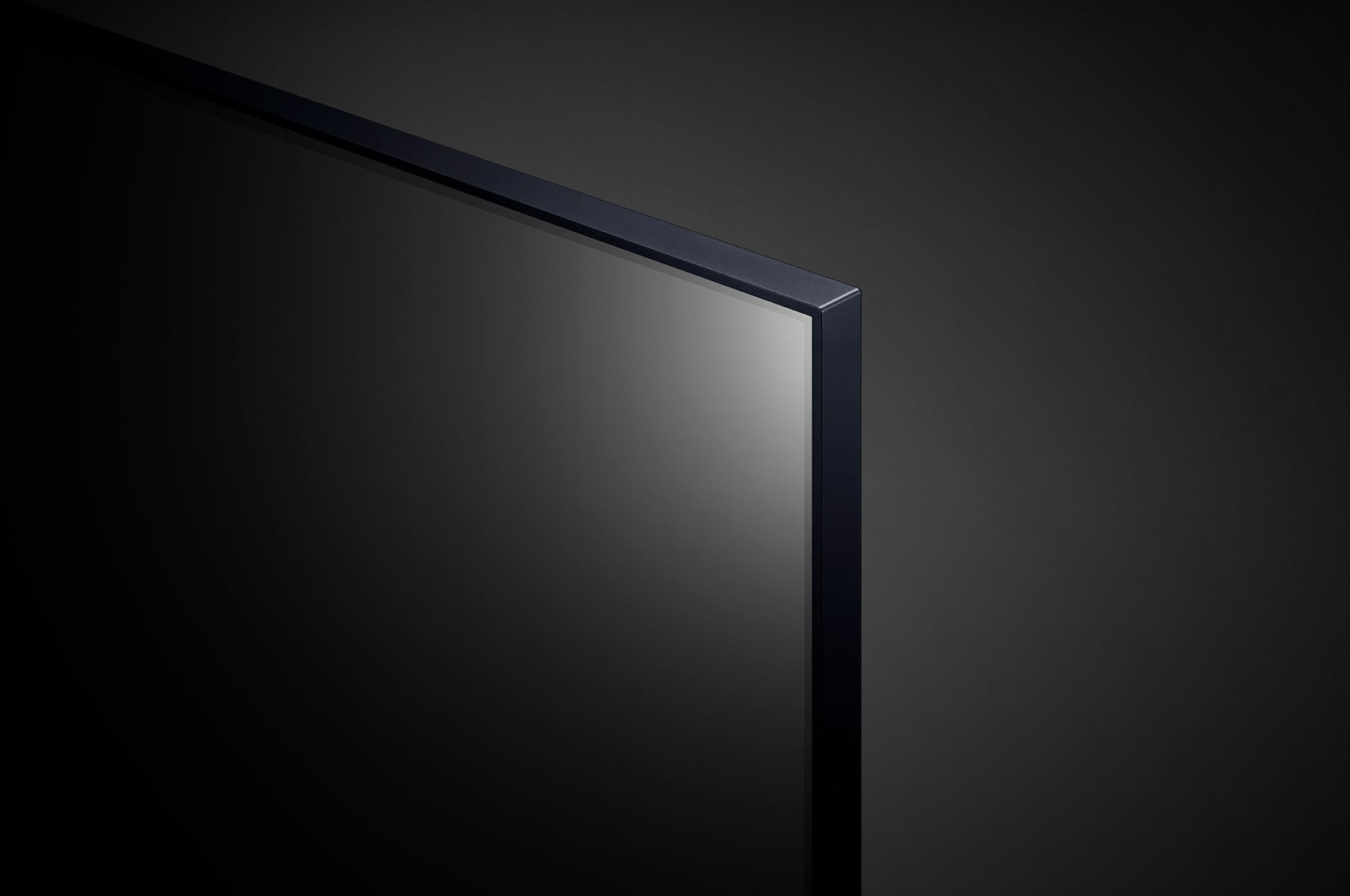 Zbliżenie ciemnego, eleganckiego telewizora. Widoczny narożnik, z czarną ramką i ciemnym ekranem.