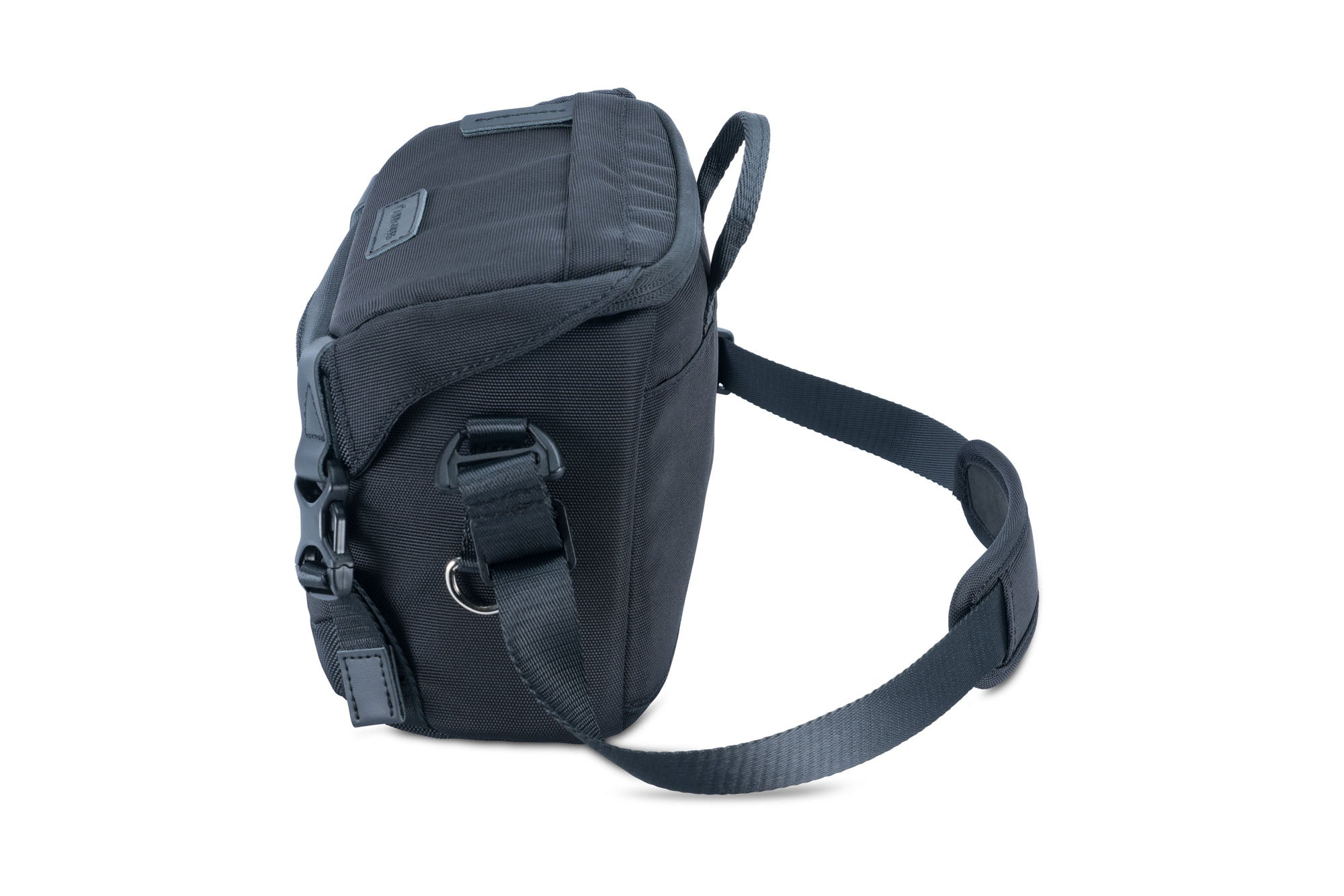Una bolsa de cámara negra con correa para el hombro sobre un fondo blanco. La bolsa está ligeramente inclinada, mostrando su lado y parte superior.