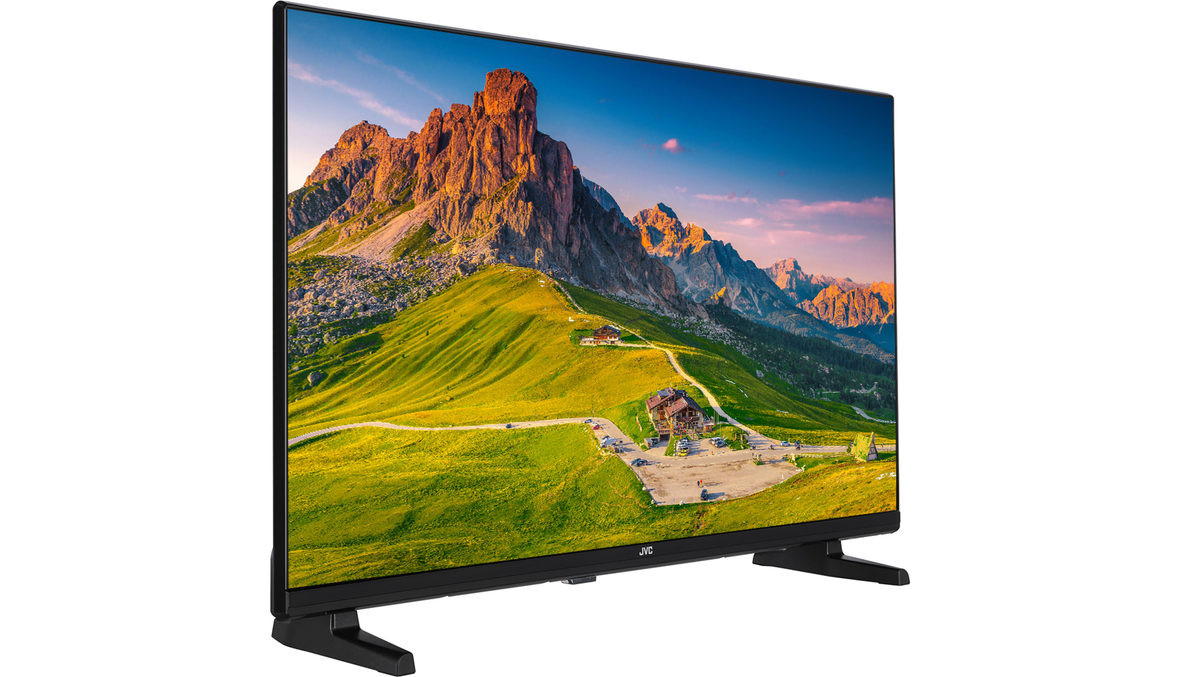 Ein JVC-Fernseher zeigt eine Berglandschaft mit grünen Feldern, einer Straße und einem Gebäude. Der Himmel ist blau mit einem Hauch von Sonnenuntergangsfarben.