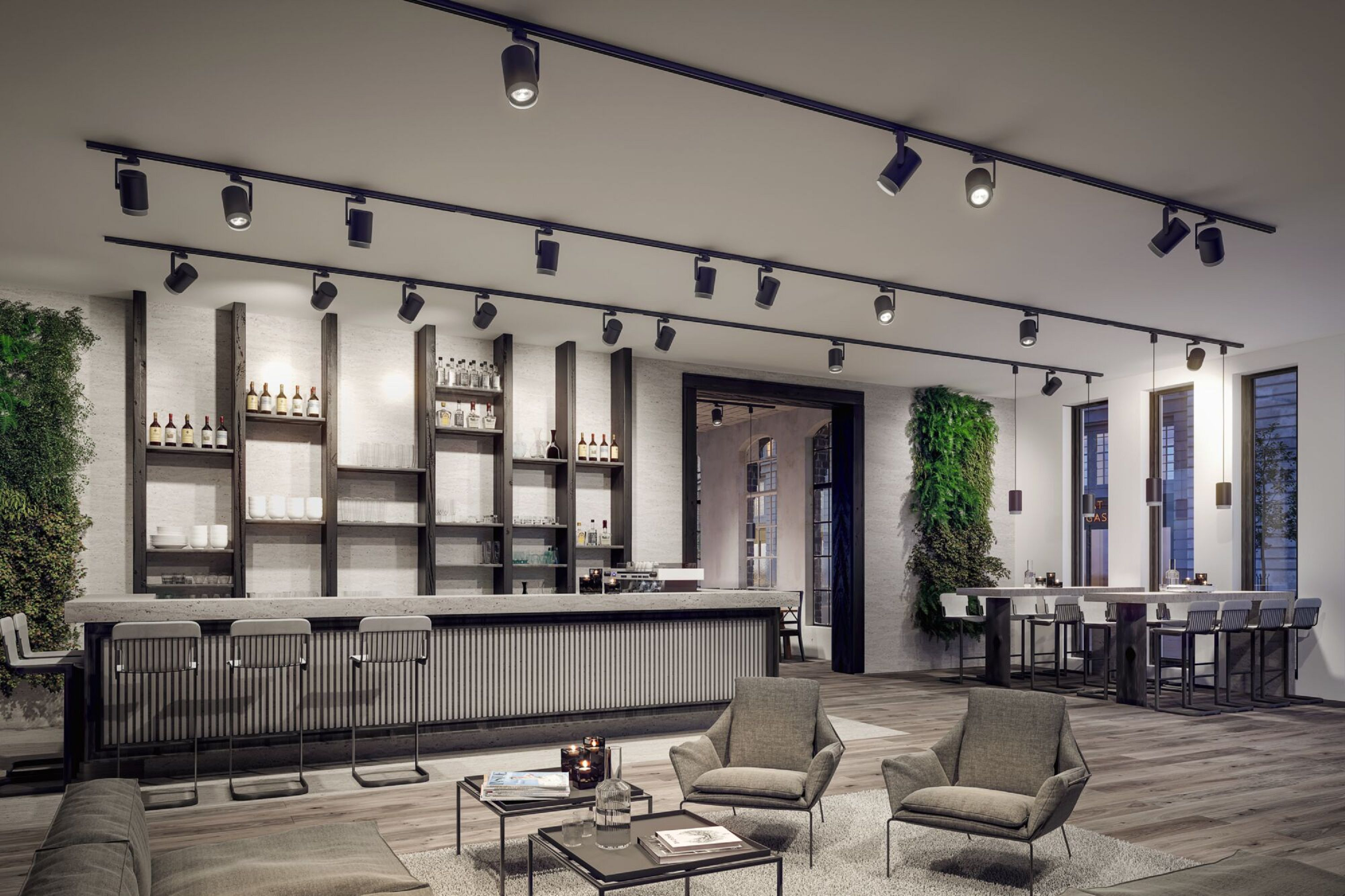 Moderne Bar mit grauer Theke, Hockern, Sesseln und Regalen. Grüne Wände, Schienenbeleuchtung und ein offener Türrahmen sind sichtbar.