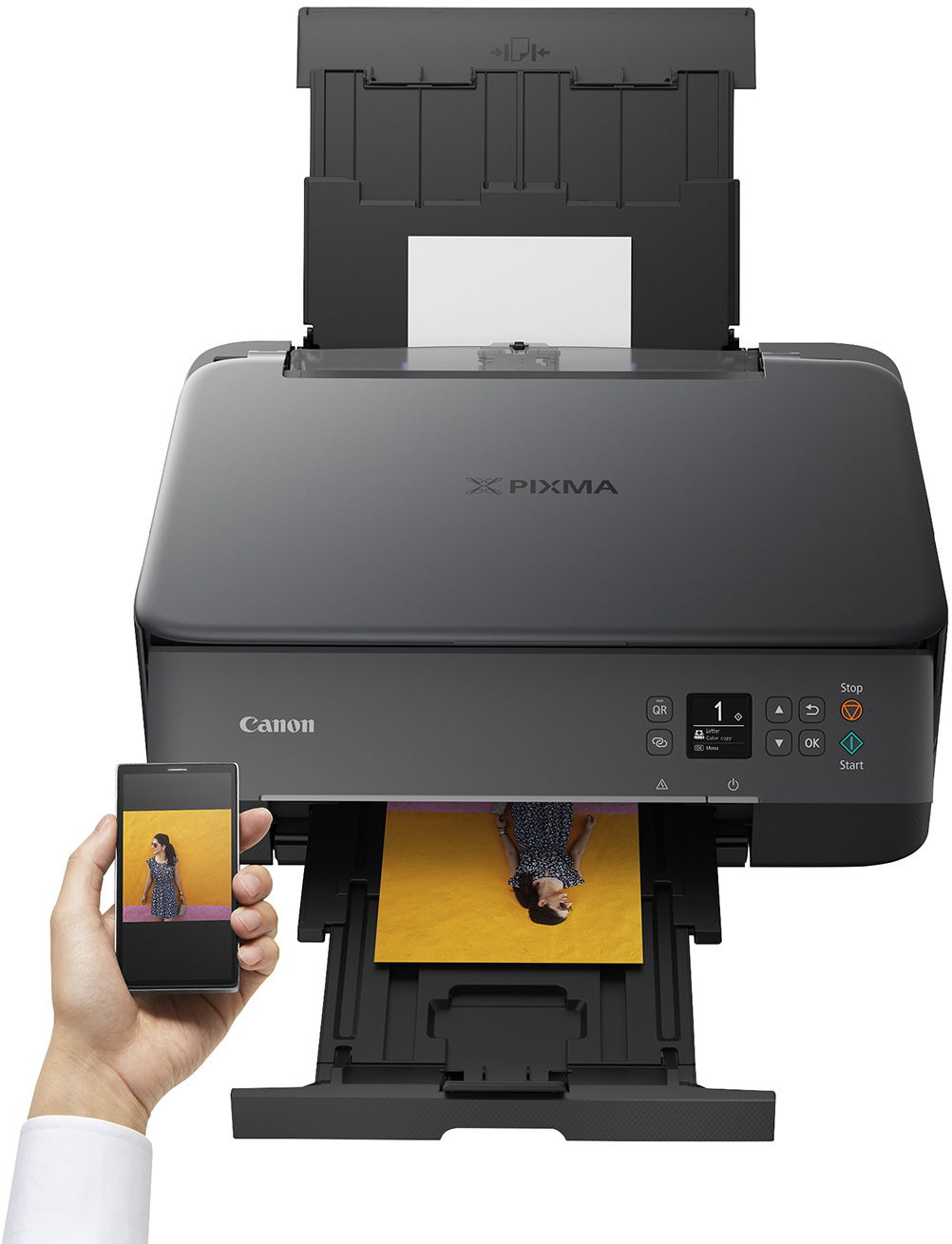 Una impresora Canon Pixma negra imprimiendo una foto desde un teléfono inteligente, que muestra a una mujer con un vestido floral, en papel amarillo.