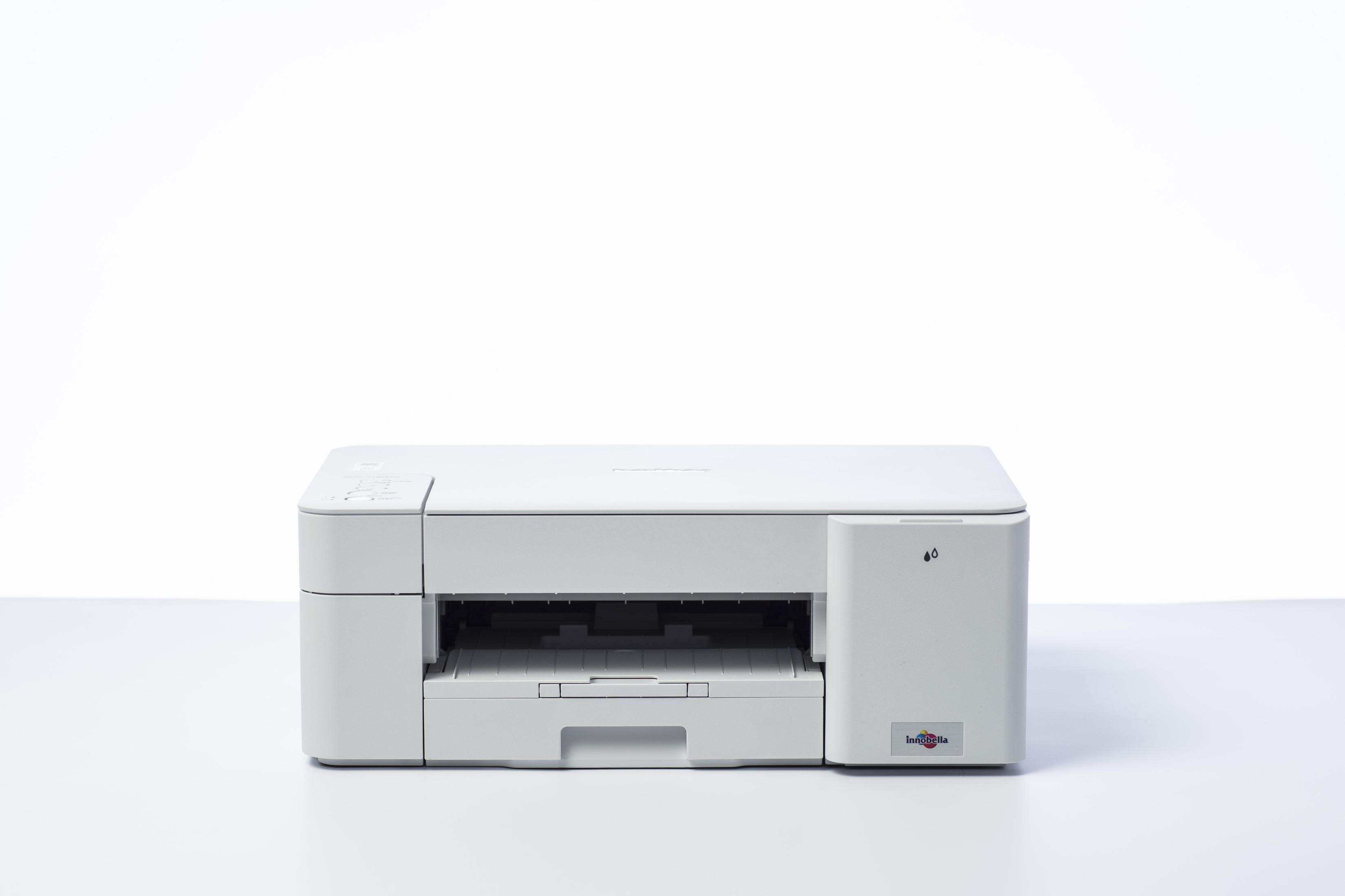 Biała drukarka na białej powierzchni. Widoczne ikony kropli atramentu i logo. Tło jest białe.