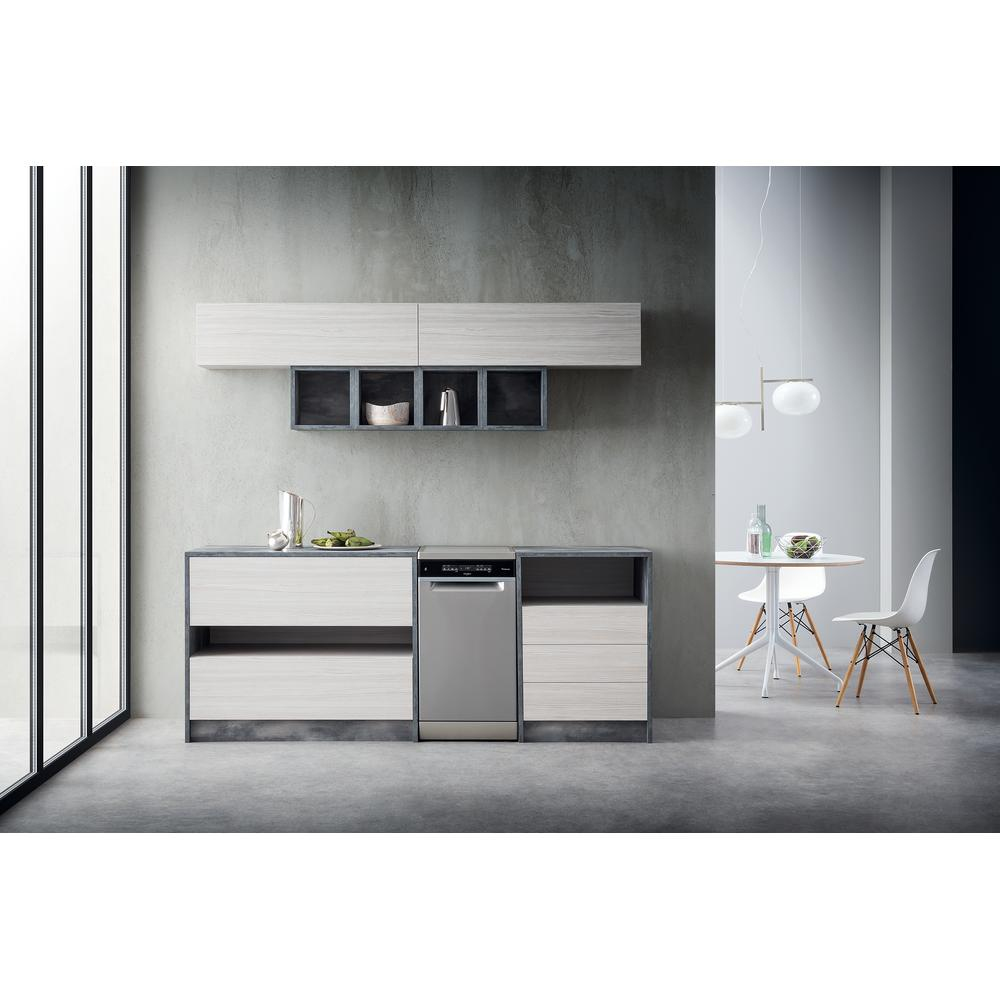 Nowoczesna kuchnia ze zmywarką, szafkami i małym stołem jadalnym. Szaro-biała kolorystyka, minimalistyczny design.