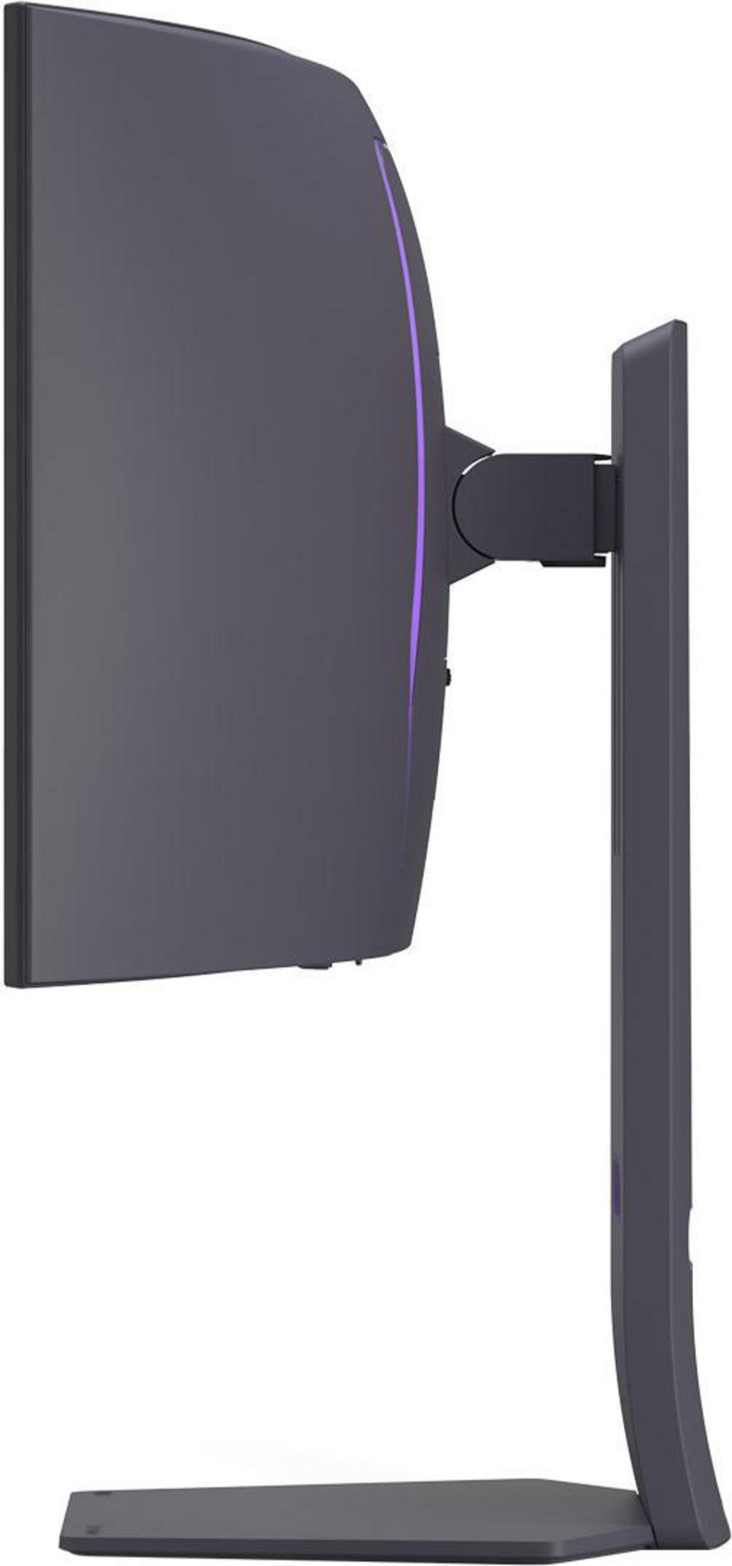 Widok z boku ciemnoszarego monitora komputera. Ma fioletowe oświetlenie akcentujące. Stojak jest zakrzywiony i również szary.
