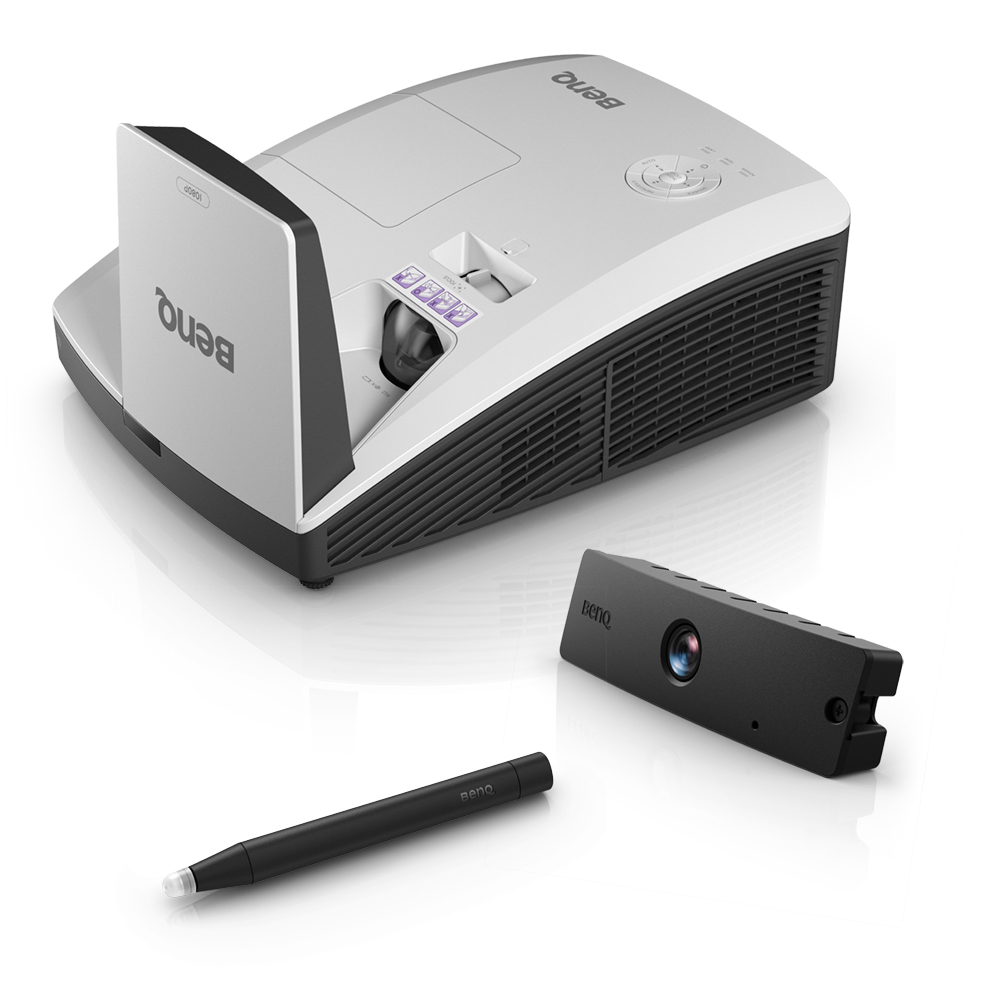 Ein weißer BenQ-Projektor, eine schwarze Kamera und ein schwarzer Stift liegen auf einer weißen Oberfläche. Der Projektor hat ein schwarzes Lüftungsgitter.
