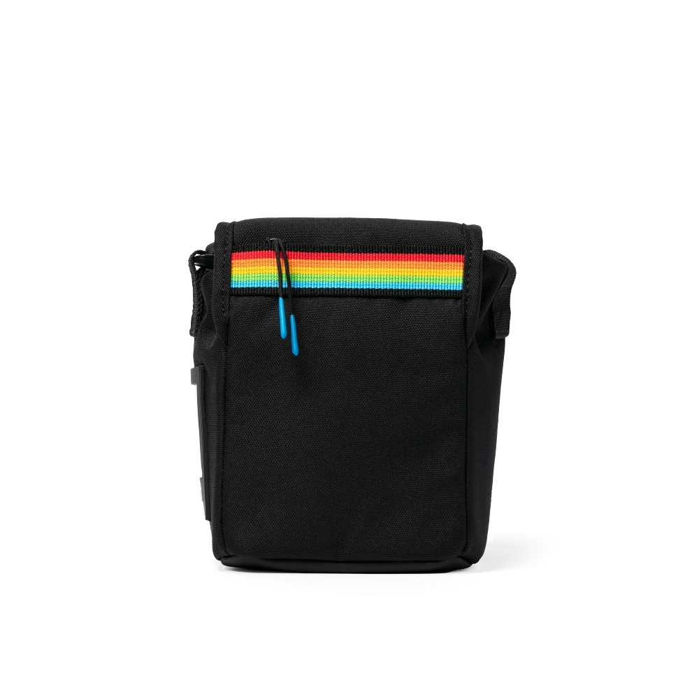 Eine schwarze Kameratasche mit einem Regenbogenstreifen oben. Eine blaue Schlaufe hängt oben. Der Hintergrund ist weiß.