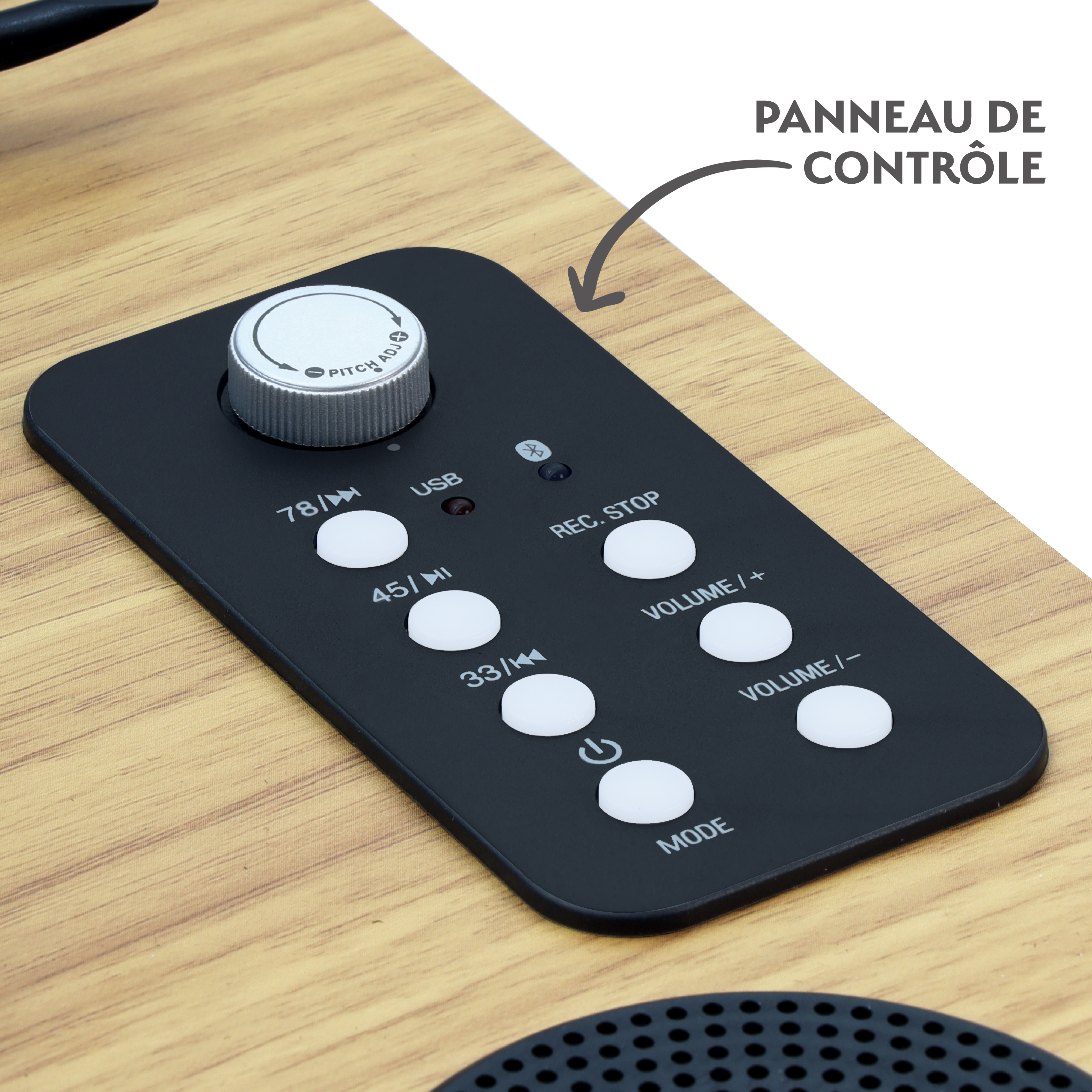 Primer plano de un panel de control con botones y una perilla sobre una superficie de madera. Los botones incluyen volumen, modo y ajustes de velocidad.