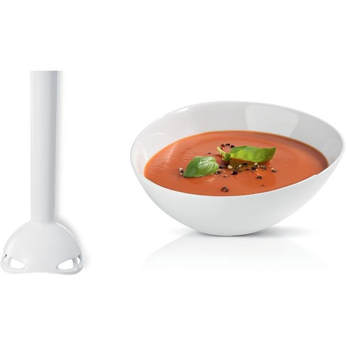 Ein weißer Mixer steht neben einer weißen Schüssel mit Tomatensuppe, garniert mit Basilikumblättern und Pfeffer.