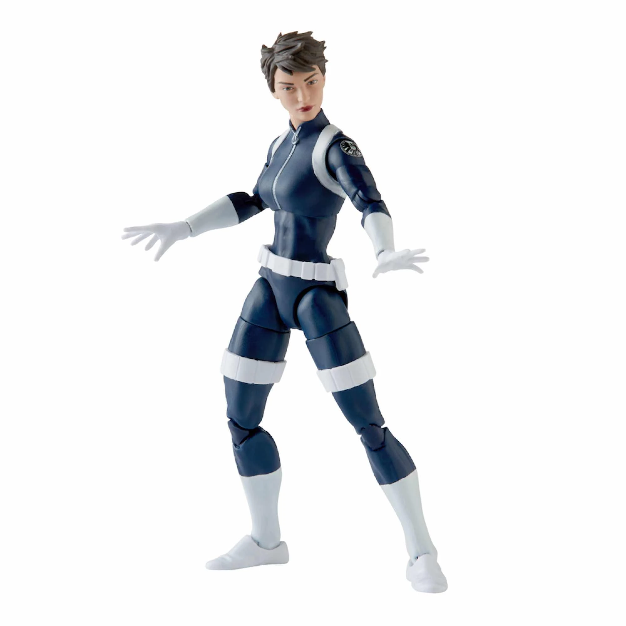 Una figura de acción femenina con traje azul marino y detalles blancos. Tiene pelo castaño corto y posa con las manos abiertas.