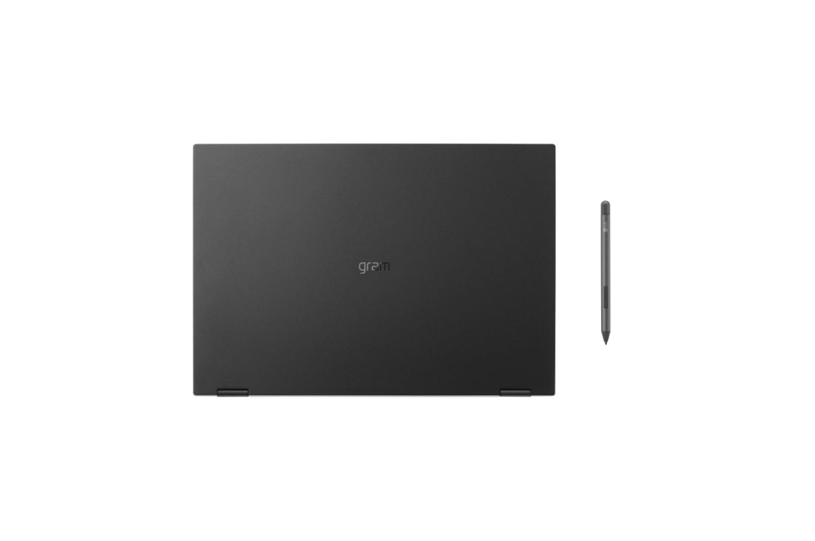 Czarny laptop, widok z góry, z marką 'gram'. Pióro obok laptopa. Białe tło.