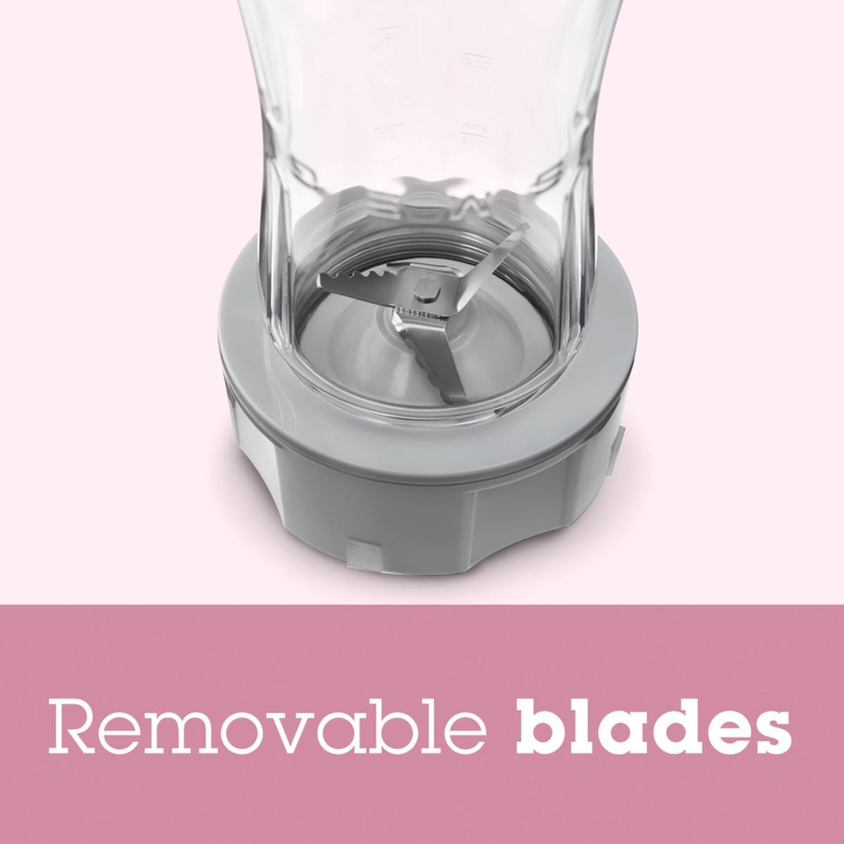 Zbliżenie podstawy blendera z ostrzami. Nad nim znajduje się przezroczysty kubek. Podstawa jest szara. Ostrza są pośrodku.