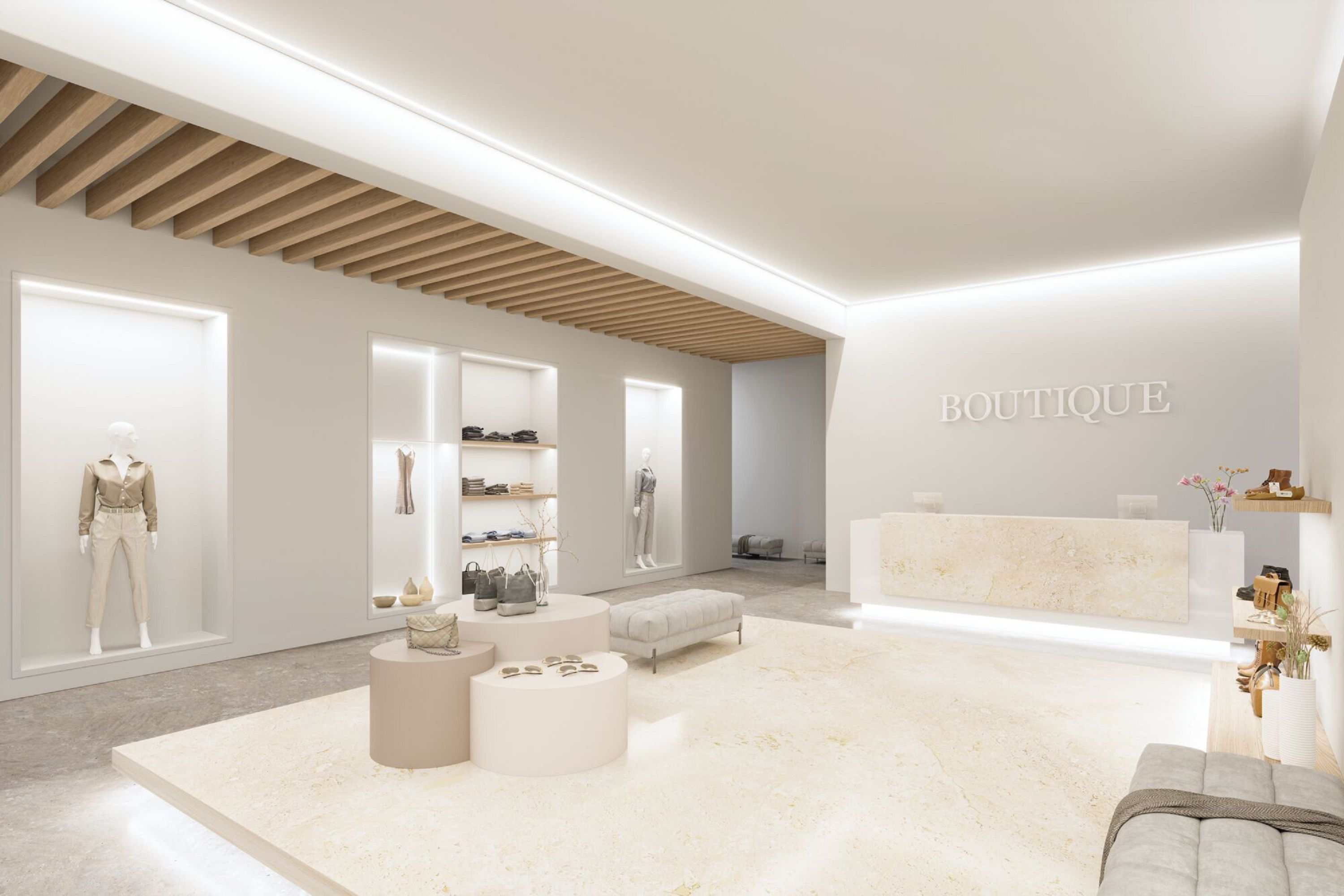 Dobrze oświetlone wnętrze butiku. Manekiny prezentują ubrania. Widoczne okrągłe stoły i recepcja.