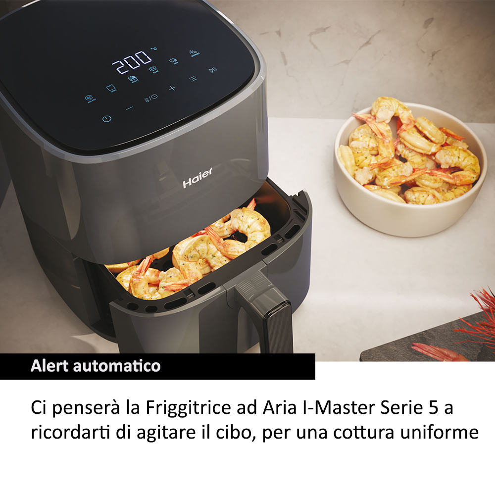 Frytkownica powietrzna z krewetkami w środku i miska krewetek obok. Frytkownica jest ciemnoszara, krewetki złote.