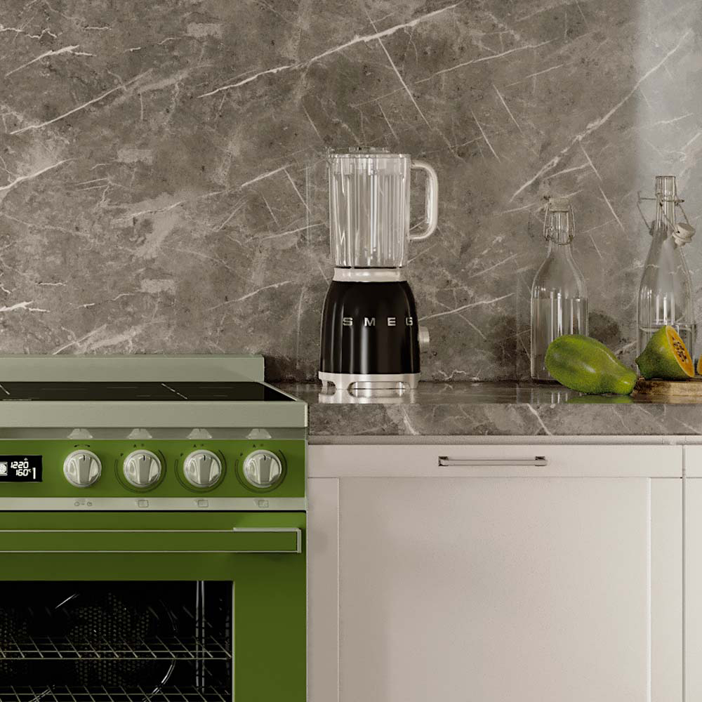 Una scena di cucina. Un forno verde accanto a un mobile bianco. Un frullatore e bottiglie sul bancone, con una papaya.
