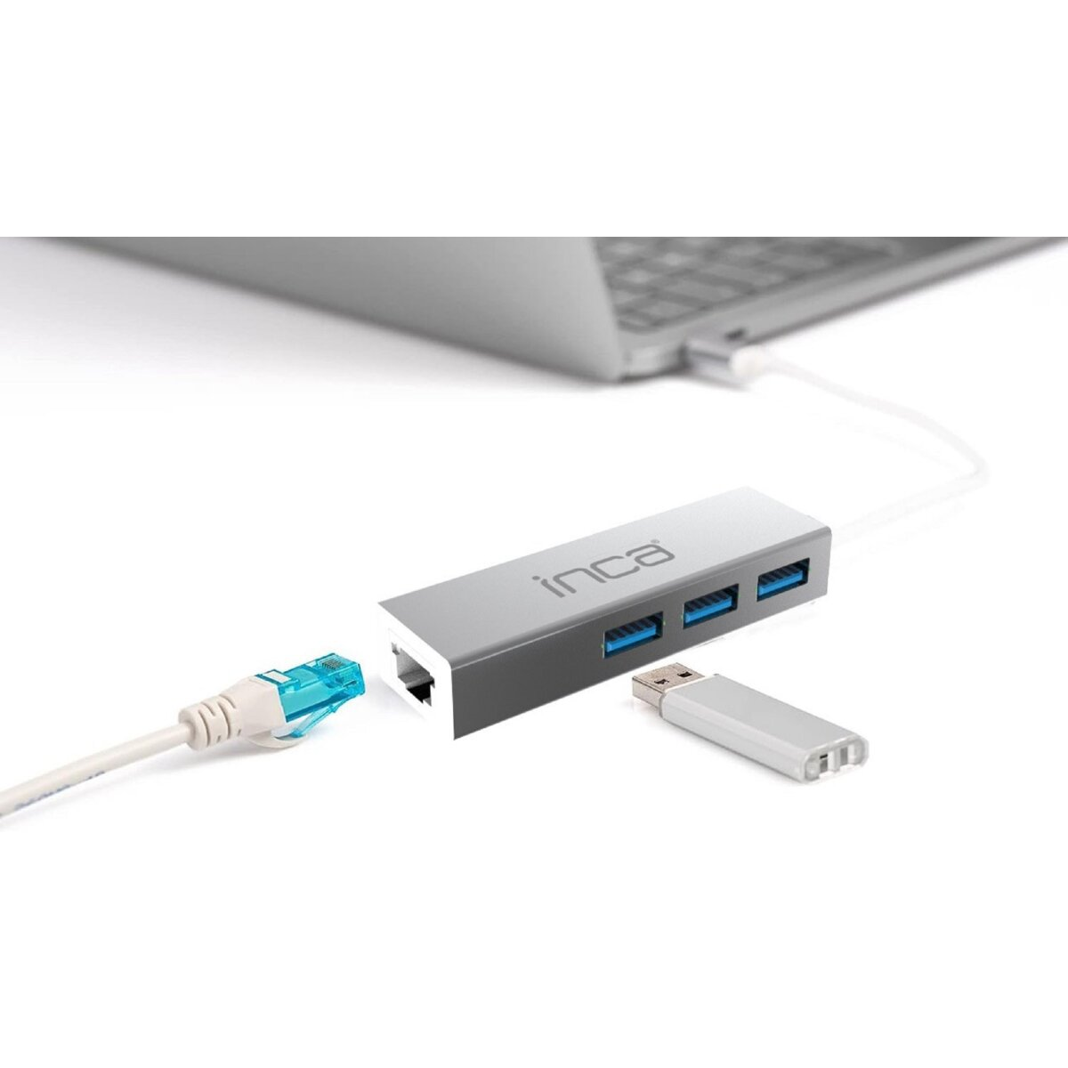 Srebrny hub USB Inca podłączony do laptopa kablem Ethernet i adapterem USB. Białe tło.