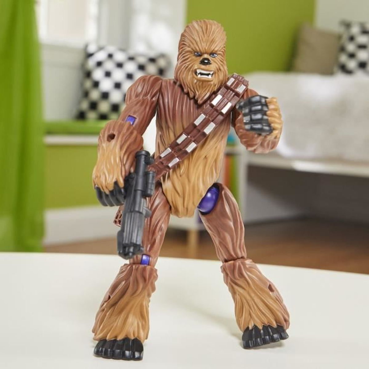 Eine Chewbacca-Actionfigur steht mit einem schwarzen Blaster und einem braunen Bandolier. Hintergrund: Zimmer mit weißen und grünen Wänden.