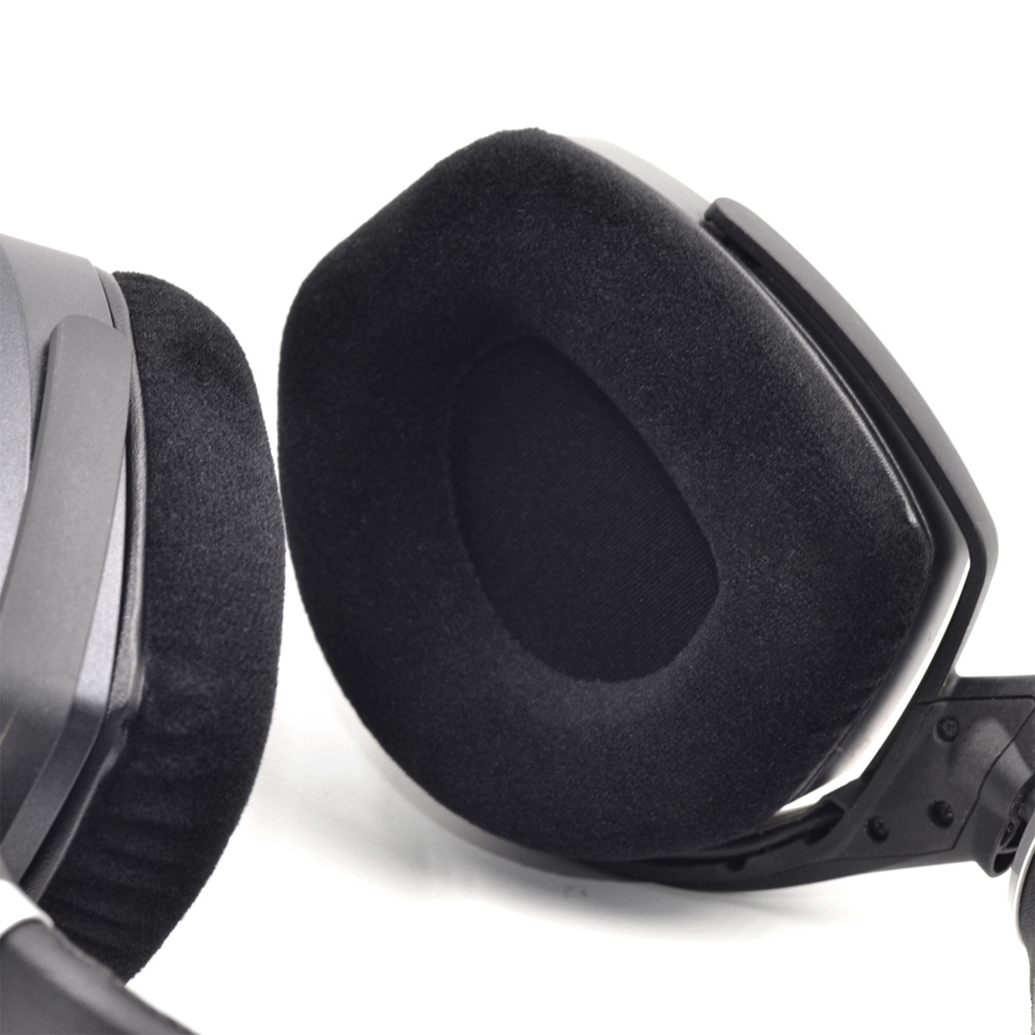 Nahaufnahme eines schwarzen und grauen Gaming-Headsets. Die Ohrmuscheln sind groß und haben weiche, schwarze Polster. Weißer Hintergrund.