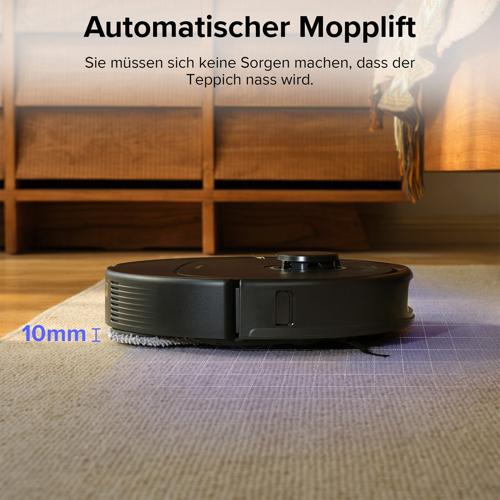 Un aspirateur robot noir sur un tapis. Texte en allemand : levage automatique de la serpillère, pas de soucis pour les tapis mouillés.