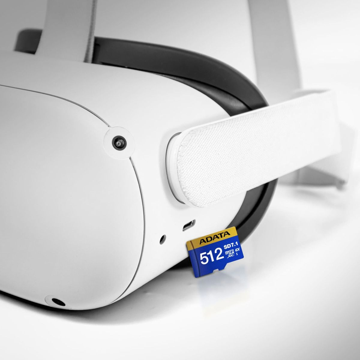 Ein weißes VR-Headset mit schwarzem Band und weißem Riemen. Eine blaue und gelbe ADATA 512GB SD-Karte ist eingesetzt.