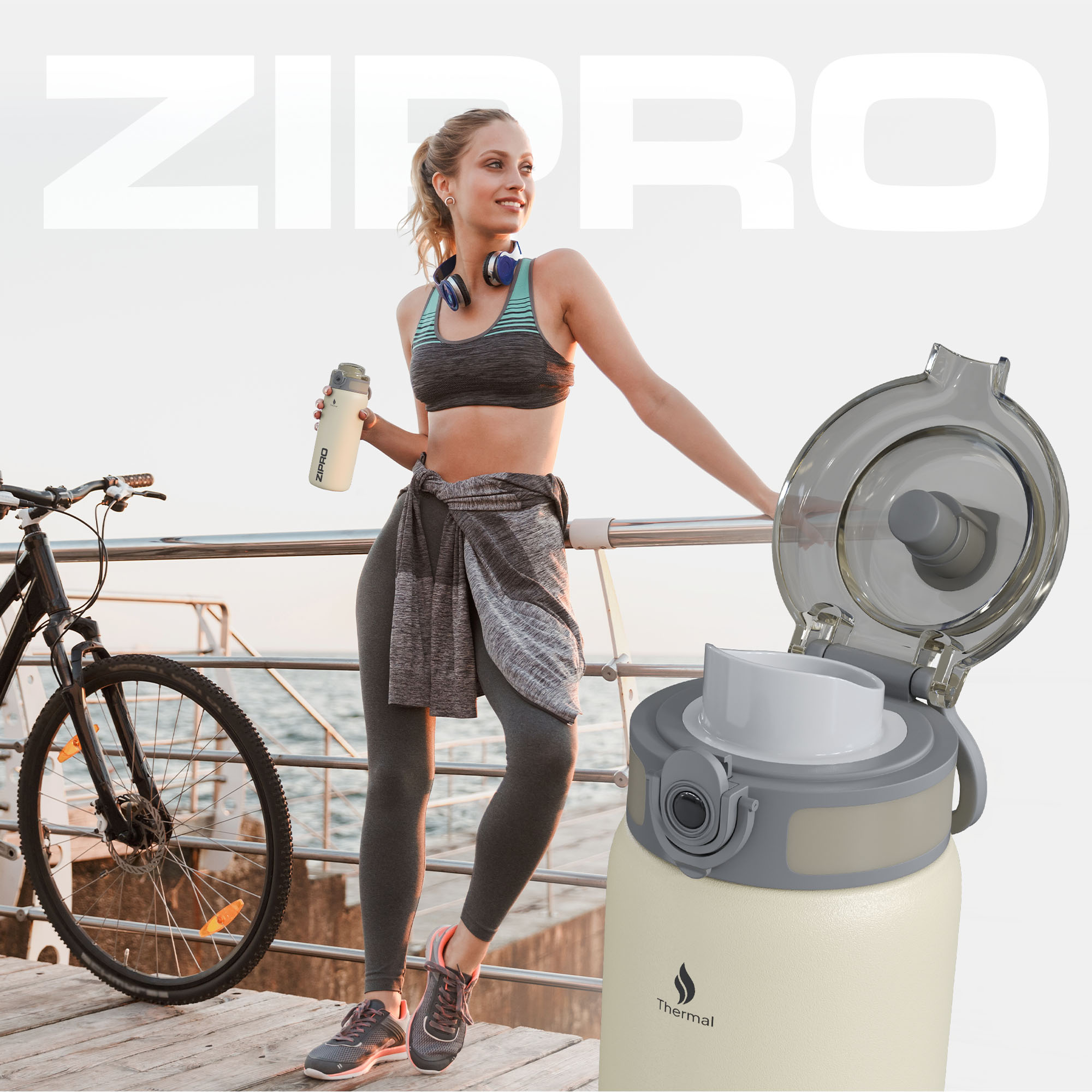 Frau mit Kopfhörern und Wasserflasche neben einem Fahrrad. Eine Thermosflasche befindet sich im Vordergrund. Das Meer ist im Hintergrund.