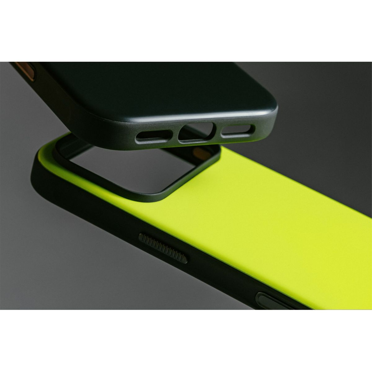 Due custodie per telefono, una nera e una giallo neon. La custodia nera è sollevata sopra quella gialla. Sfondo grigio.