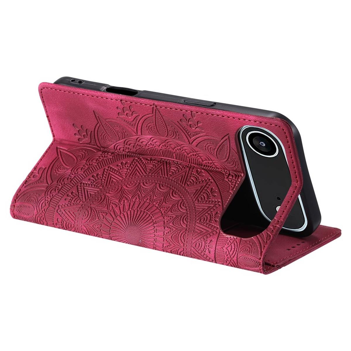 Eine weinrote Handyhülle mit Mandala-Design ist geöffnet und hält ein schwarzes Handy. Die Hülle befindet sich auf einer weißen Oberfläche.