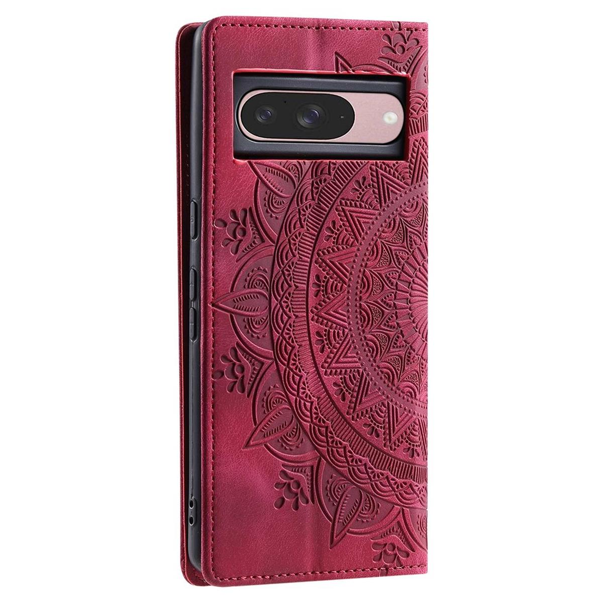 Eine rote Handyhülle mit Mandala-Design. Ein Telefon mit schwarzer Kamera ist sichtbar. Die Hülle ist geöffnet, das Telefon ist sichtbar.