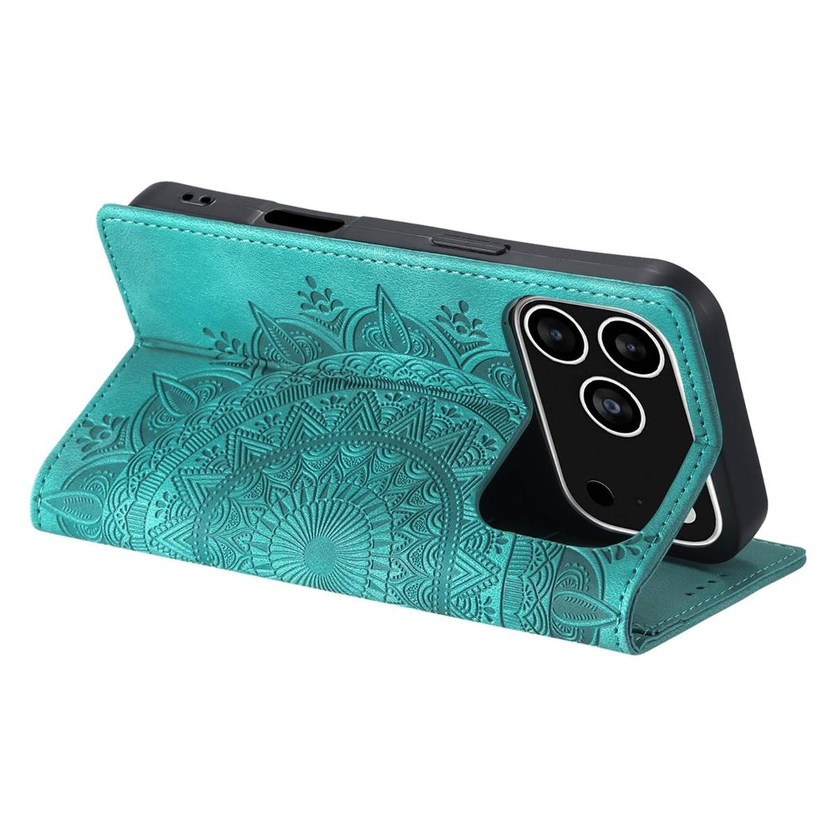 Eine türkisfarbene Handyhülle mit Mandala-Design hält ein schwarzes Telefon. Die Hülle ist offen und zeigt die Kameralinsen des Telefons.