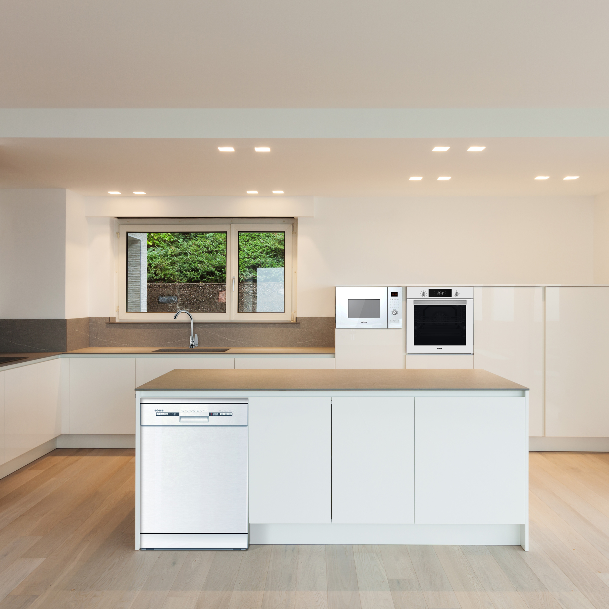 Cocina moderna con gabinetes blancos, electrodomésticos y piso de madera. Lavavajillas al frente, ventana con vegetación.